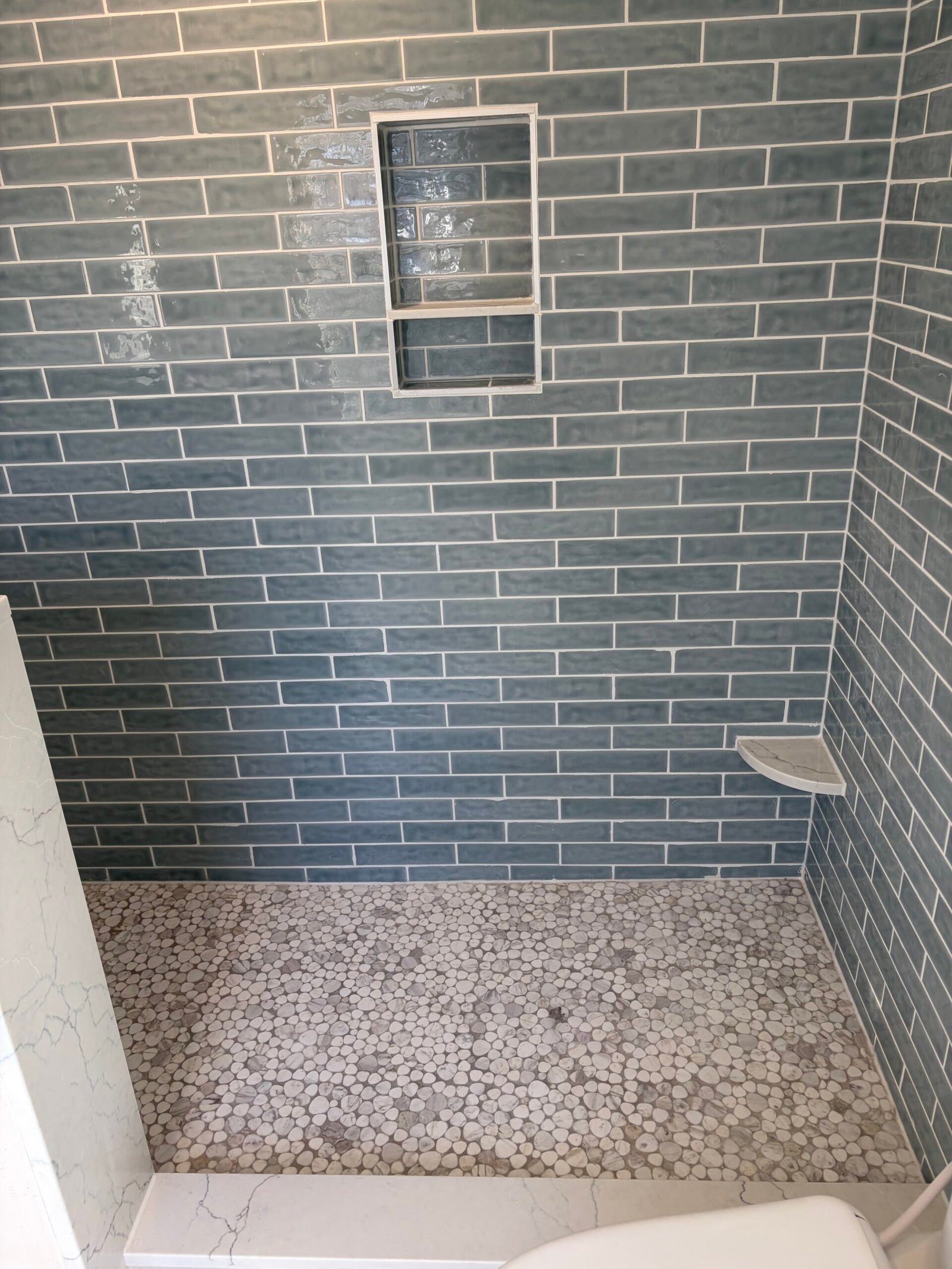 After: the recessed niche, corner shelf and mosaic shower floor.