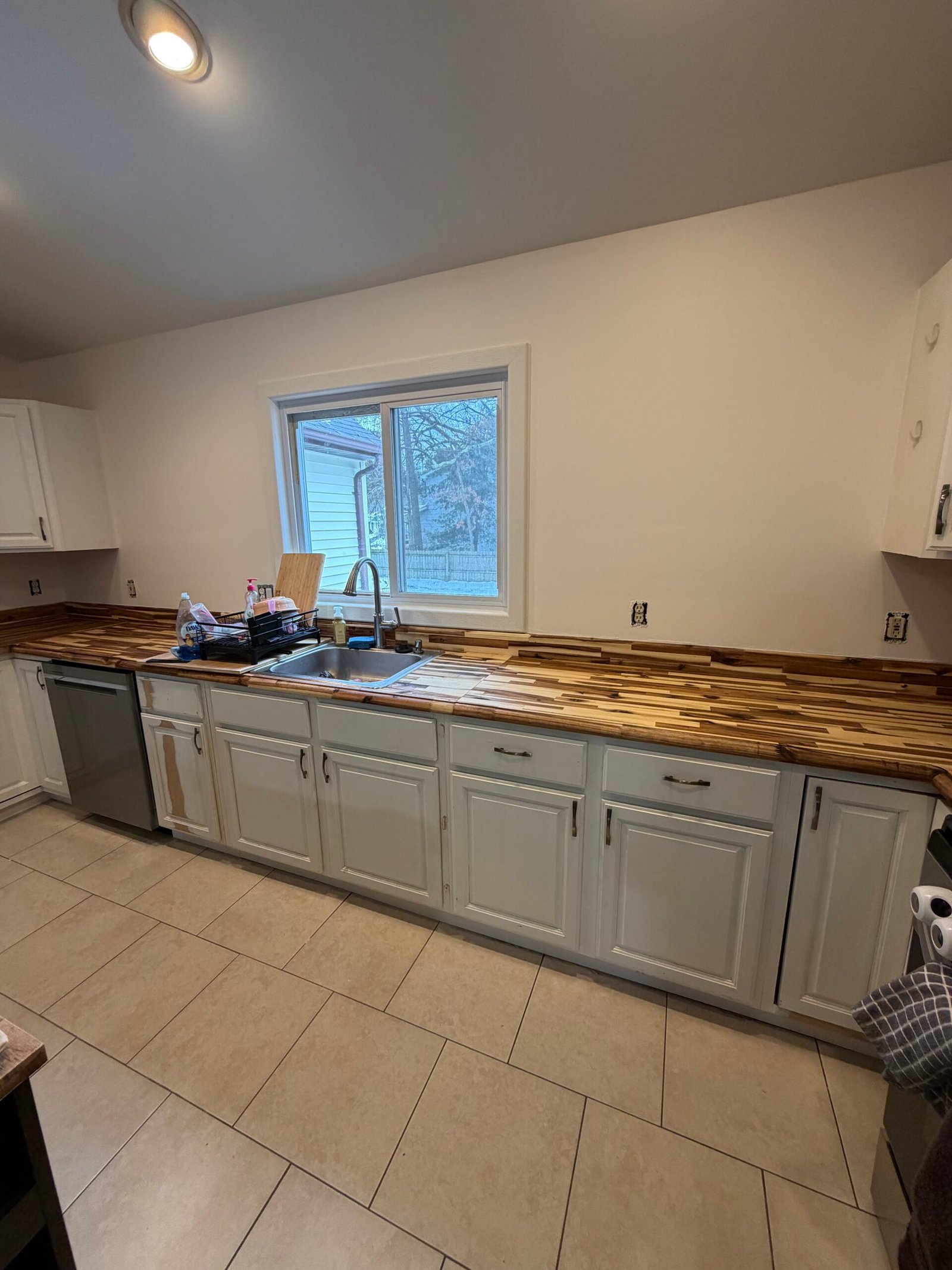 After: the freshly painted walls, white upper cabinets and soft gray base cabinets.