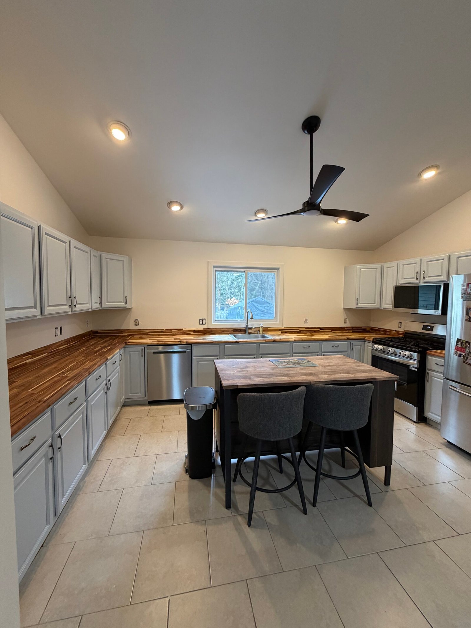After: the renewed kitchen with coordinated cabinets and wood worktops.