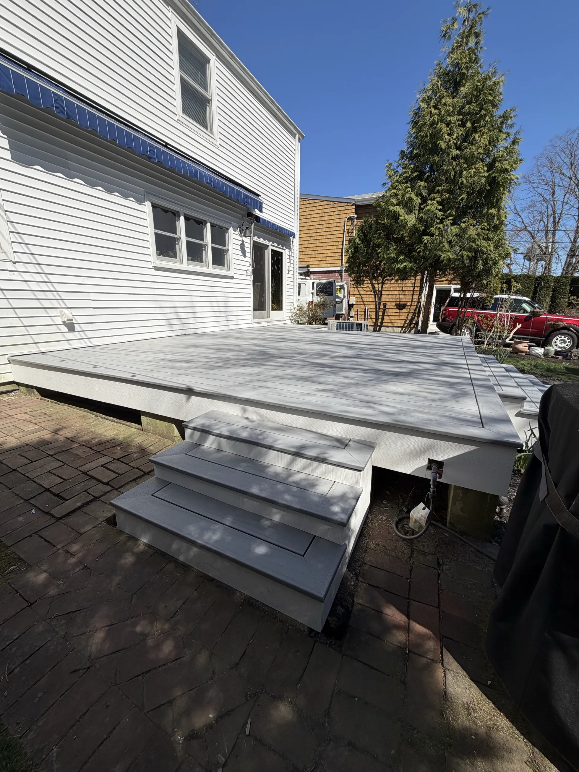 The renewed side stair and gray deck surface