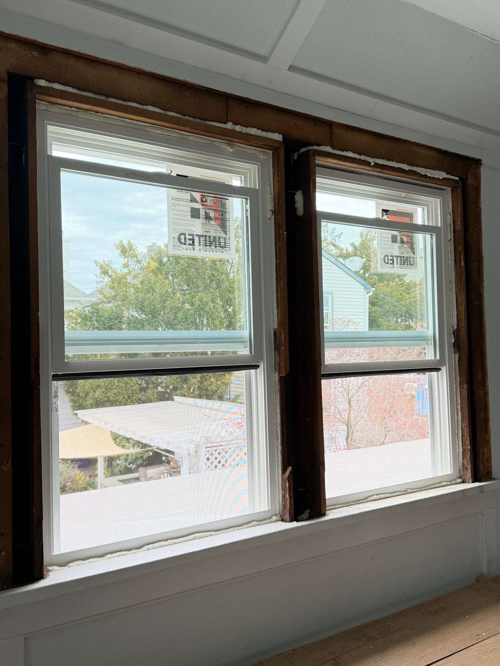 White-framed replacement windows in the paired openings before the trim was finished.