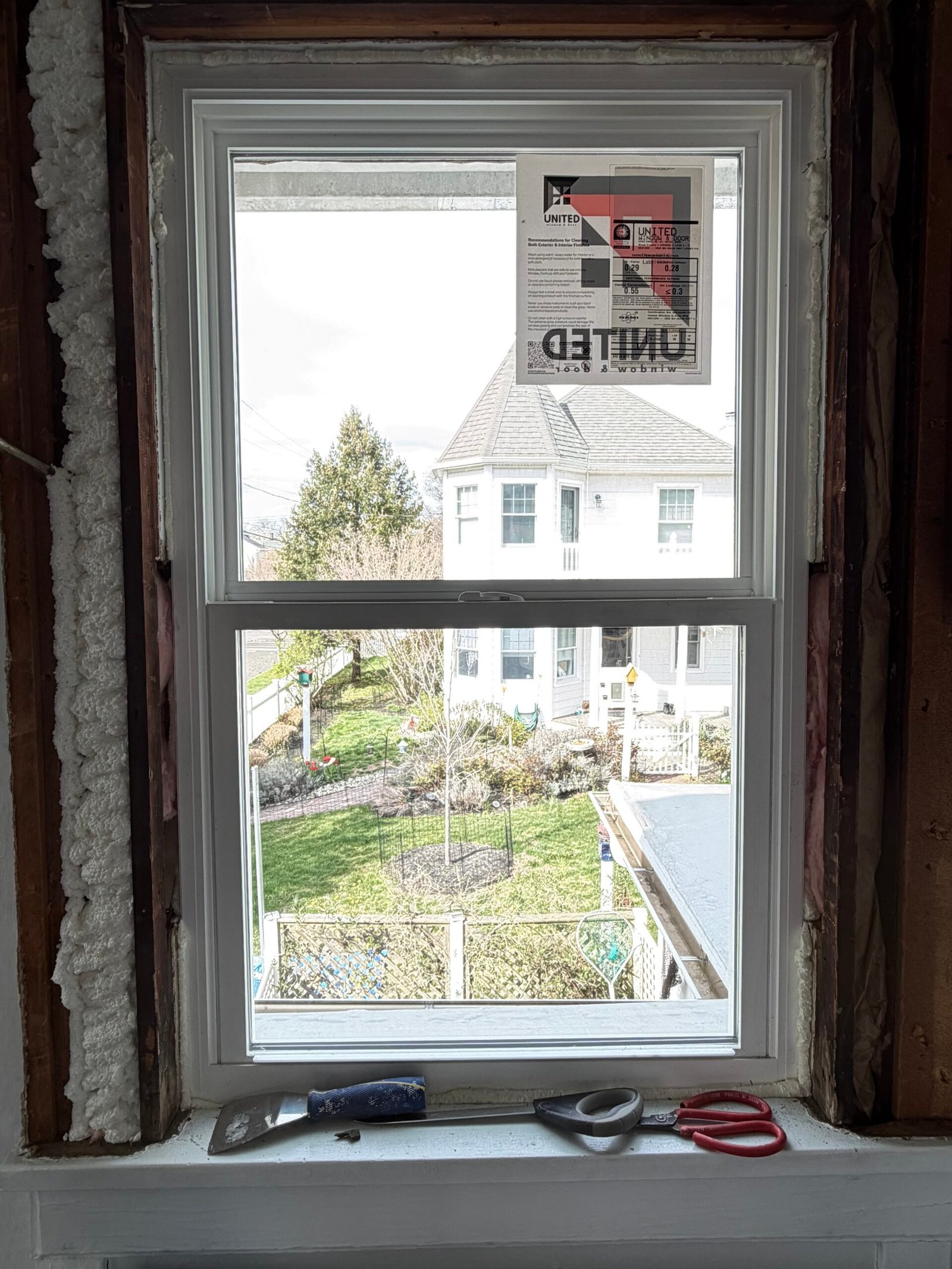 Perimeter foam visible around a single replacement window before casing was fitted.