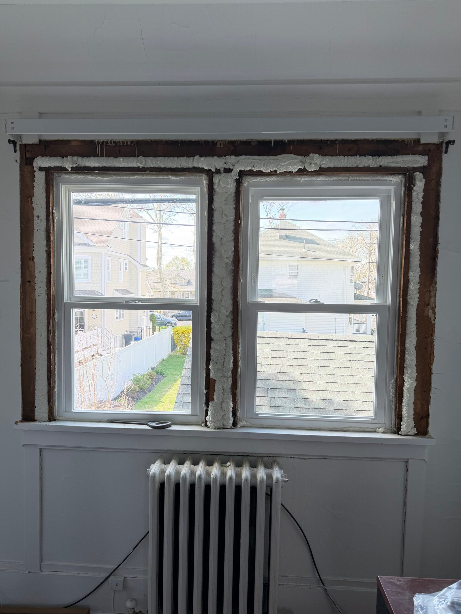 Foam around the paired replacement frames before the surrounding trim was completed.