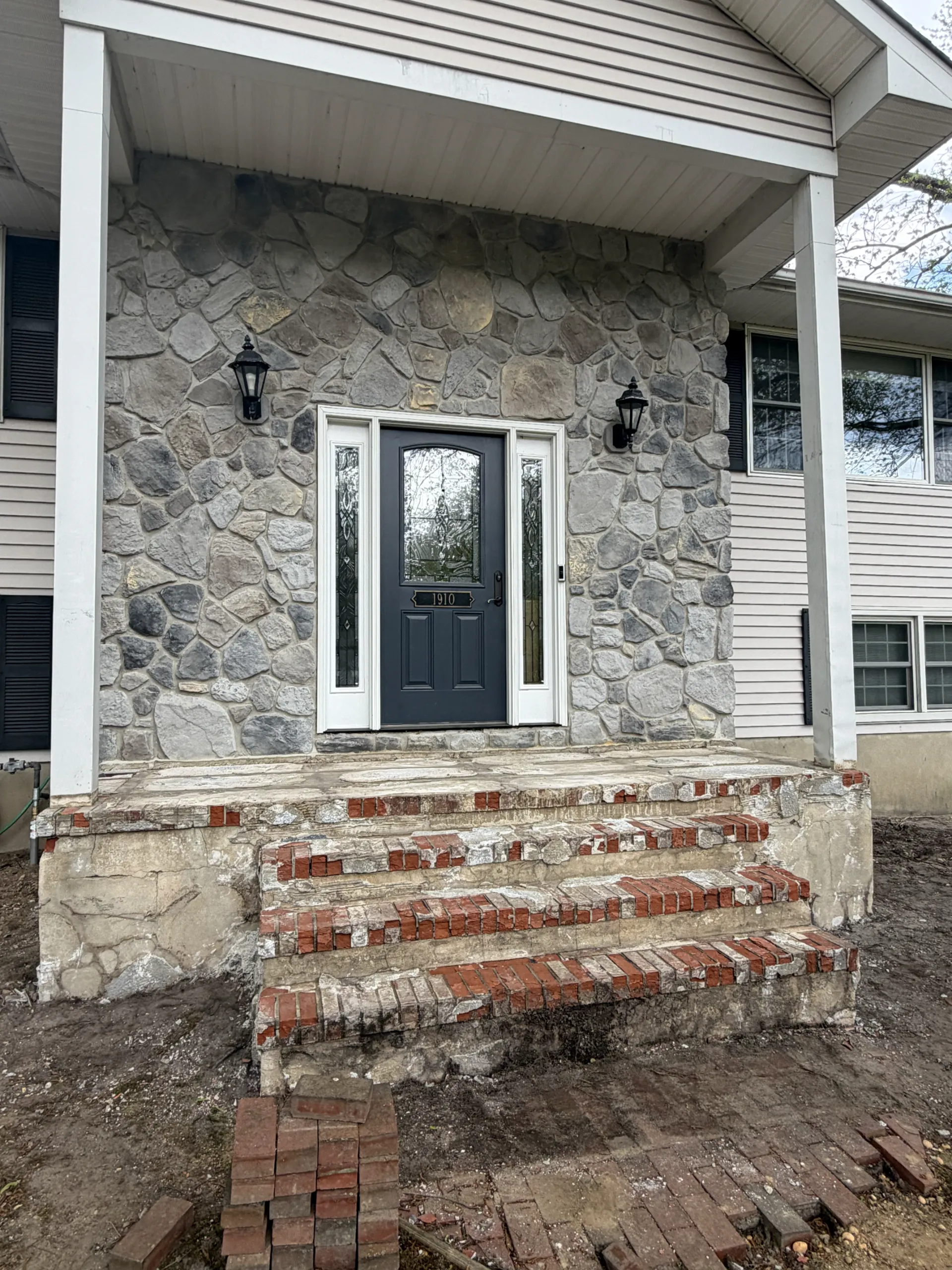 Starting stage: exposed brick steps and porch base before the new finish