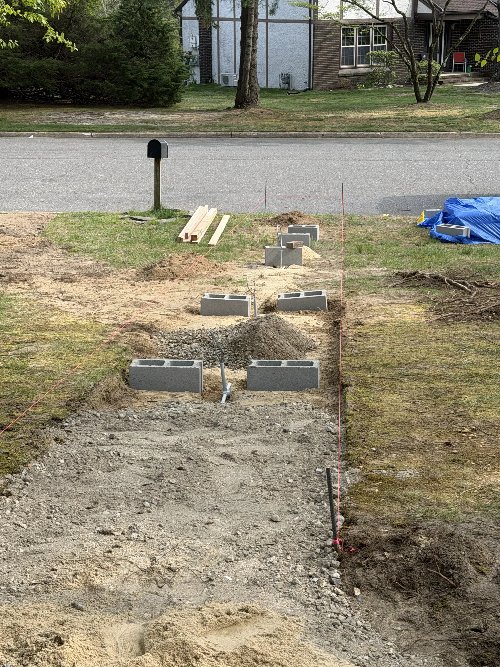 Prepared front walkway route with masonry blocks at the setting-out stage
