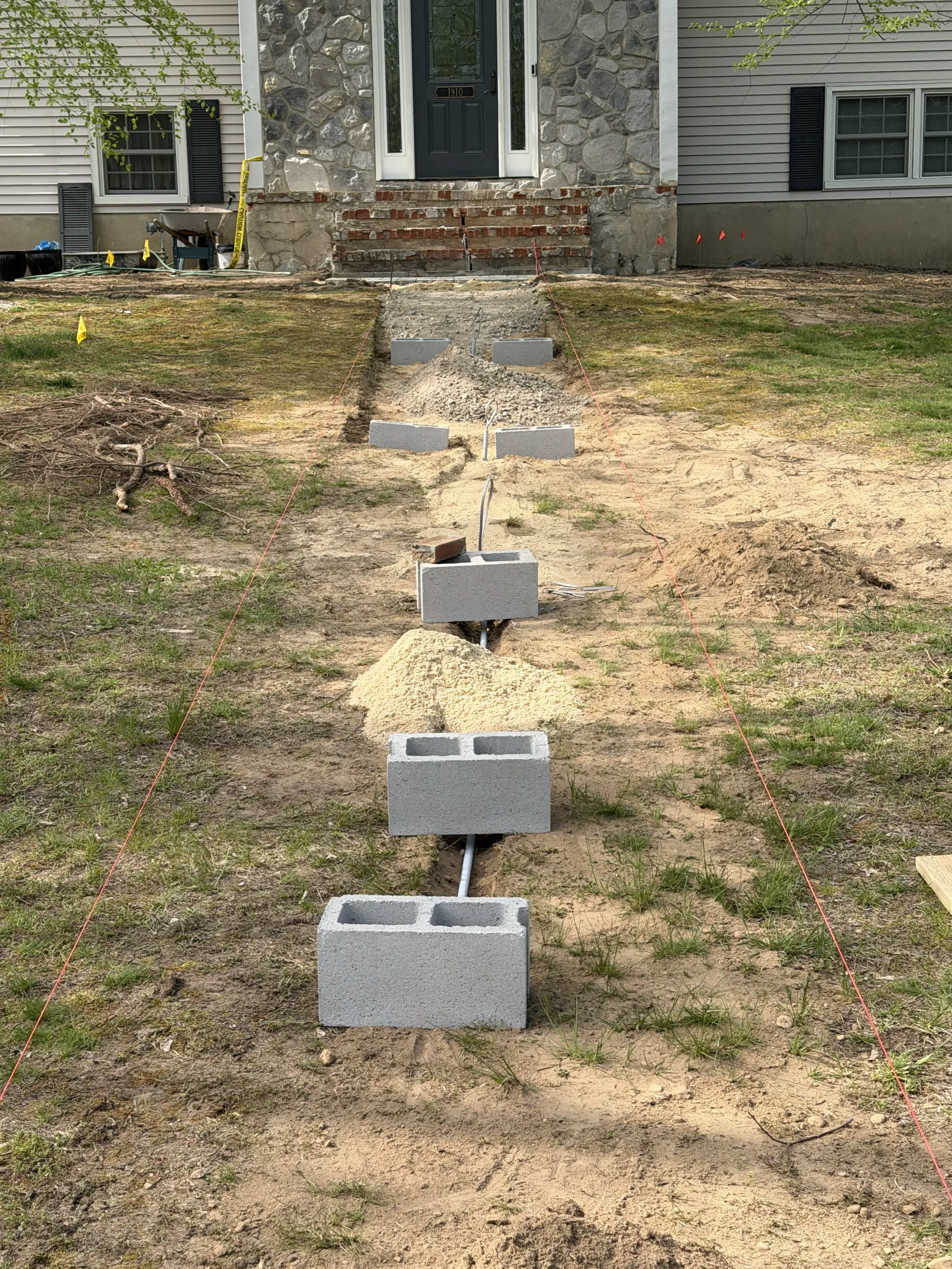 Early walkway preparation facing the house and existing front steps