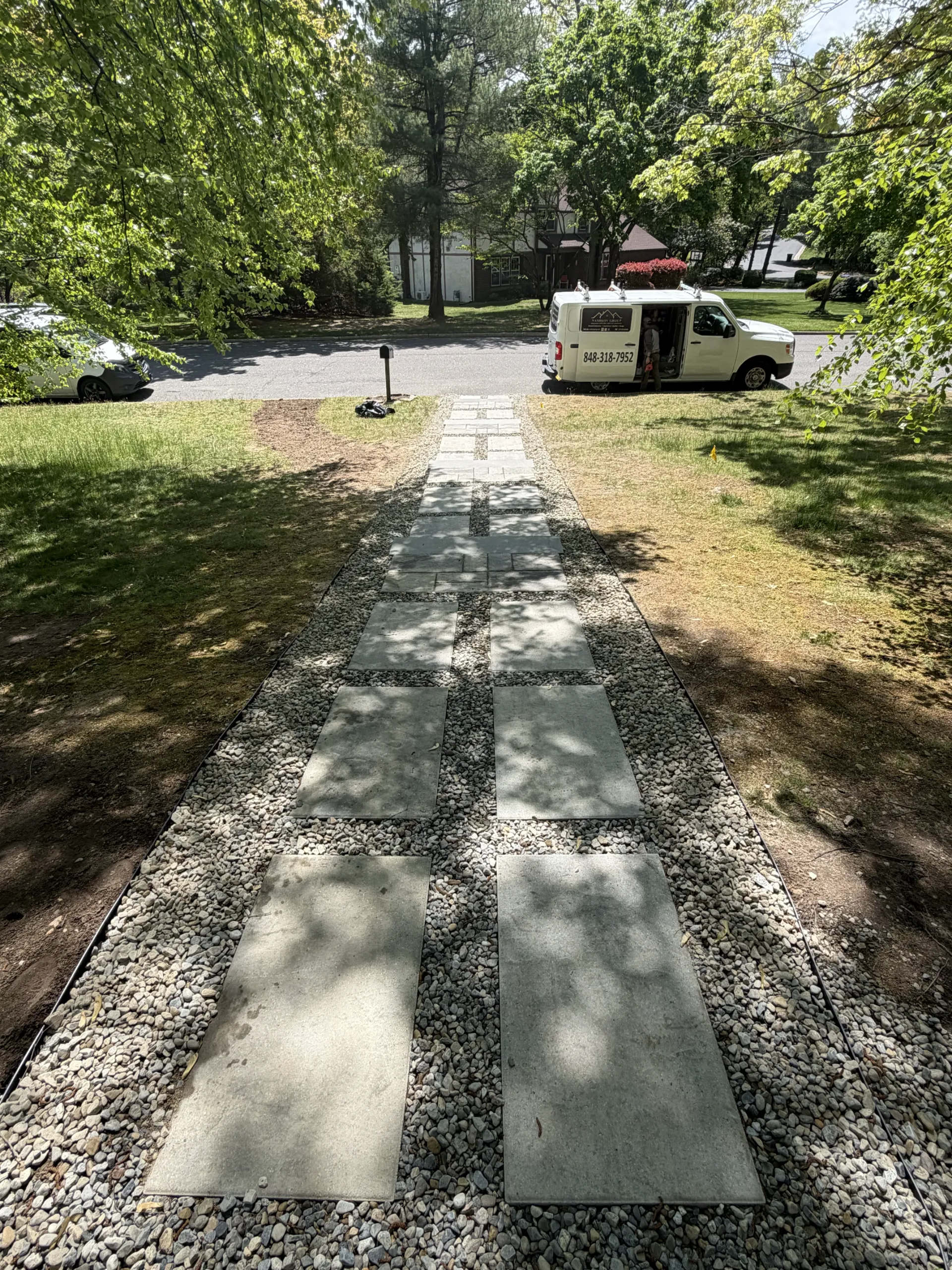 Finished front walkway with large gray paving slabs and gravel joints
