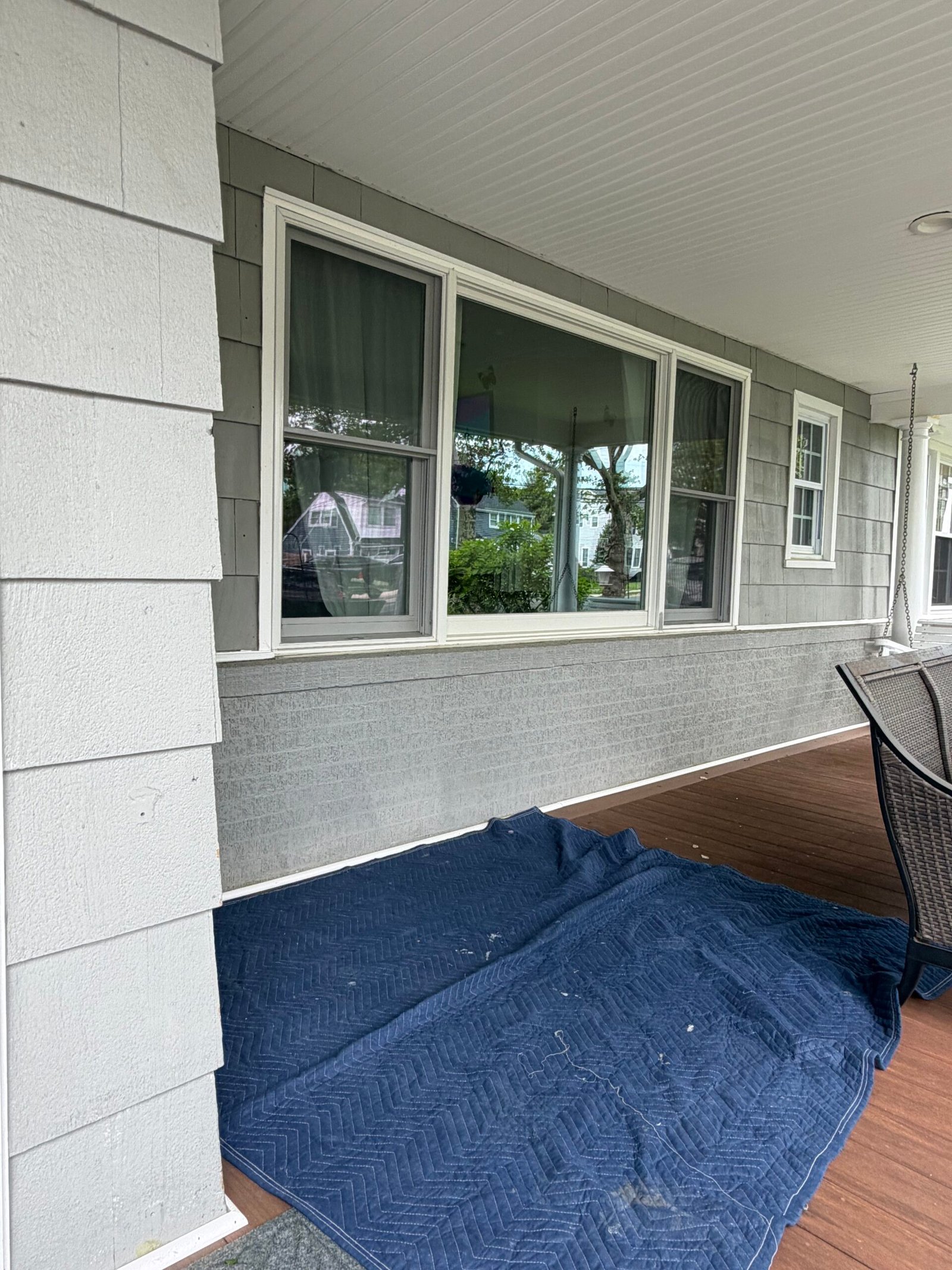 A protective drop cloth covering the porch floor beside the exterior wall.