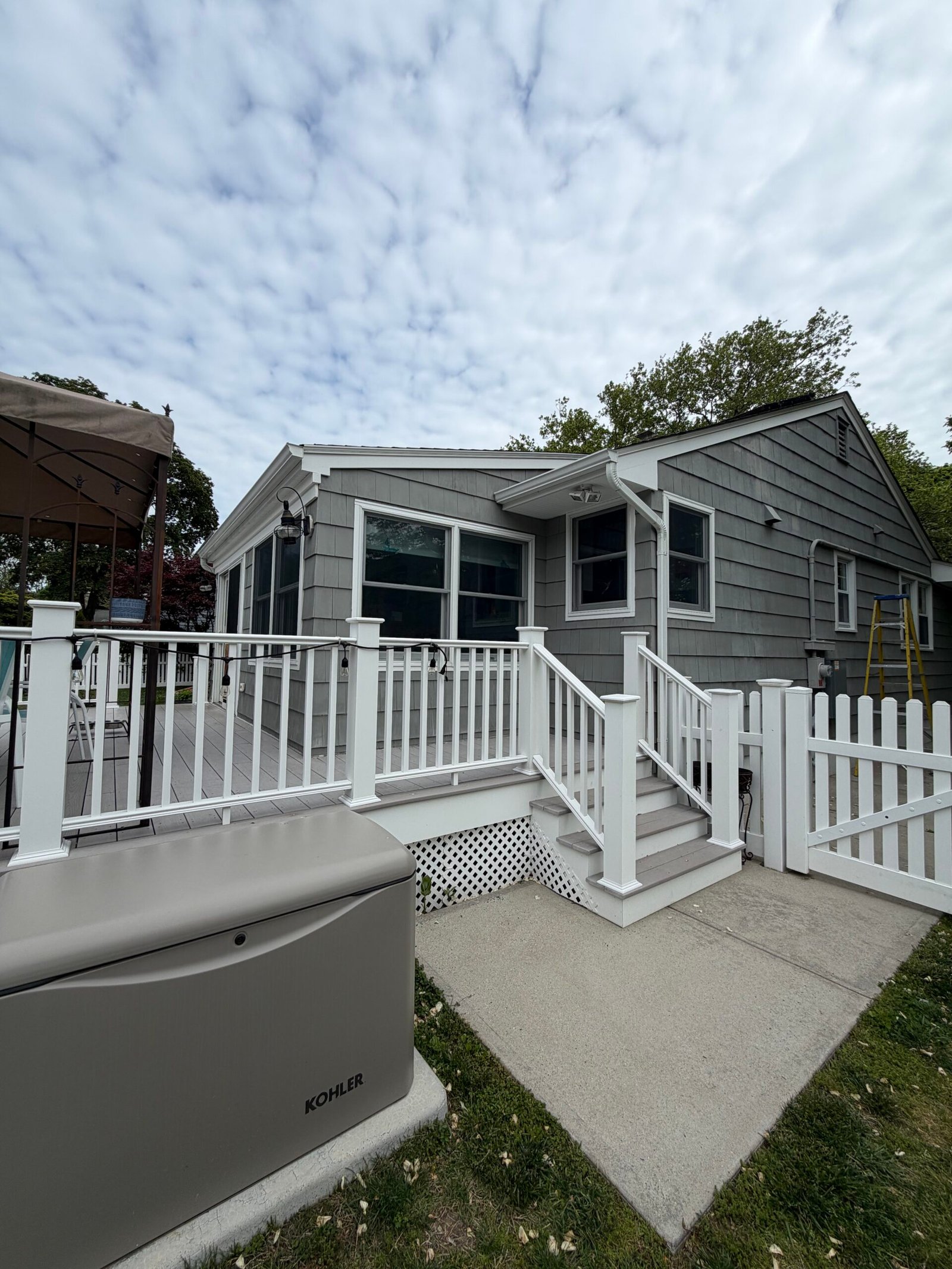 Before: the rear walls beside the raised deck, stairs and white railings.