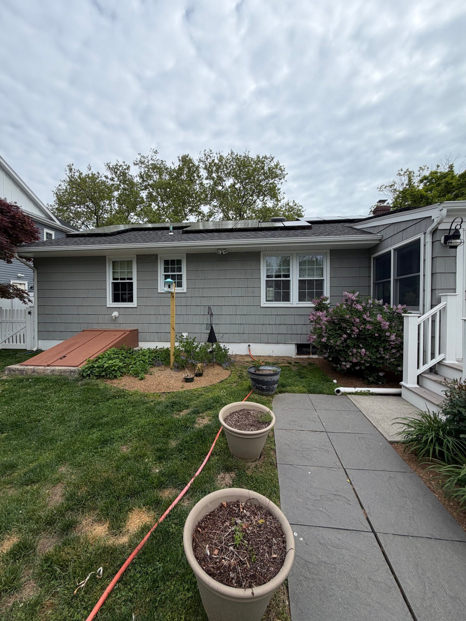 Before: the rear elevation beside the lawn, basement access and paved path.