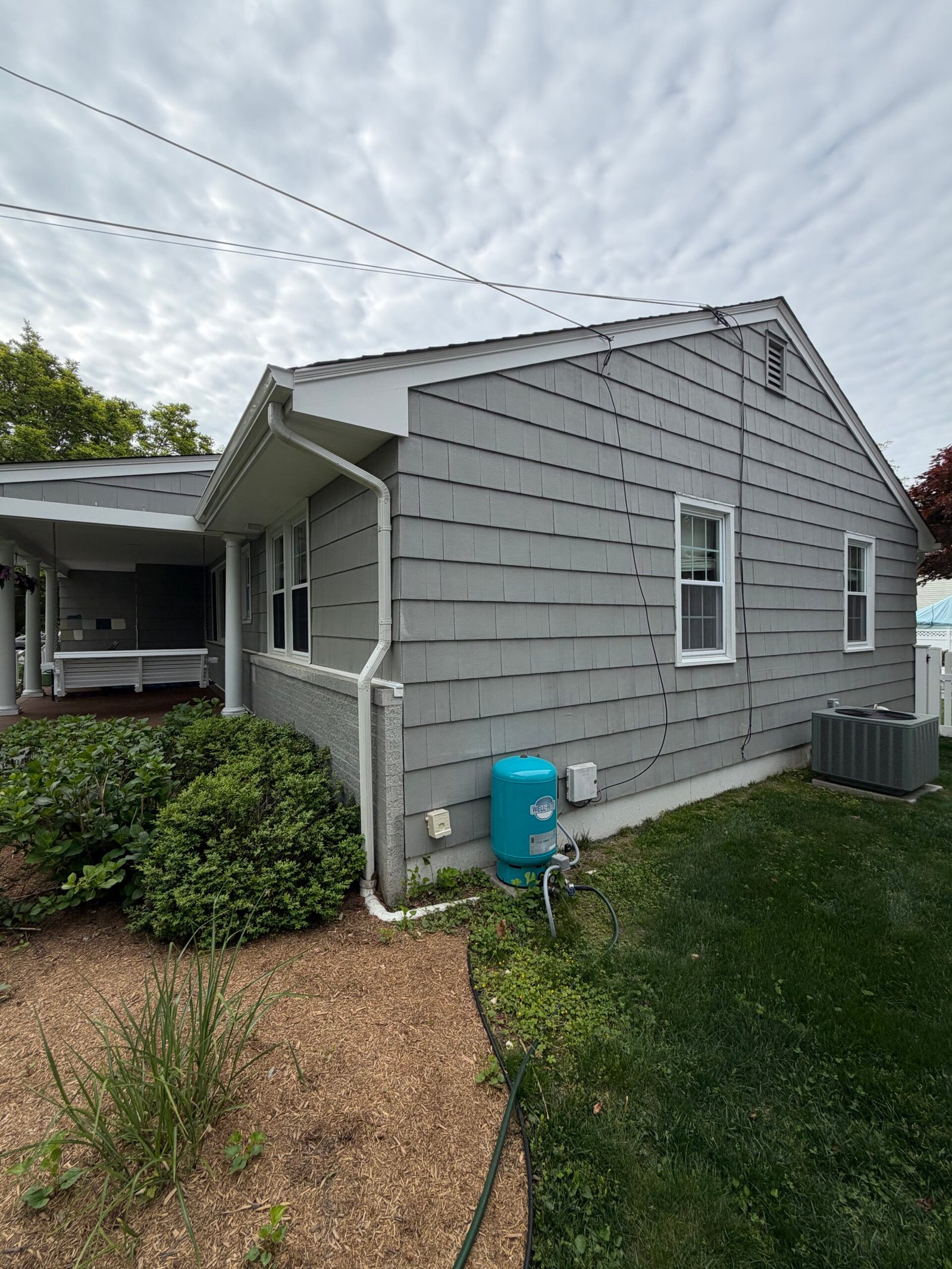 Before: the side gable, siding and lower wall area beside the garden.