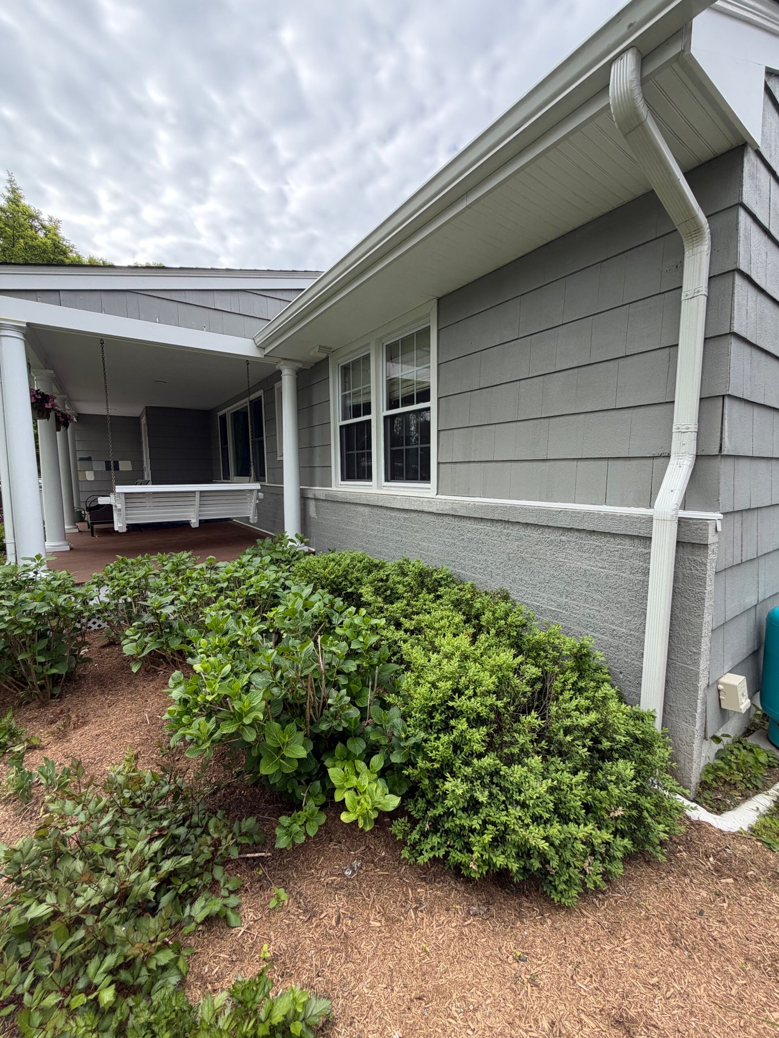Before: a closer view along the side wall beneath the white roofline.