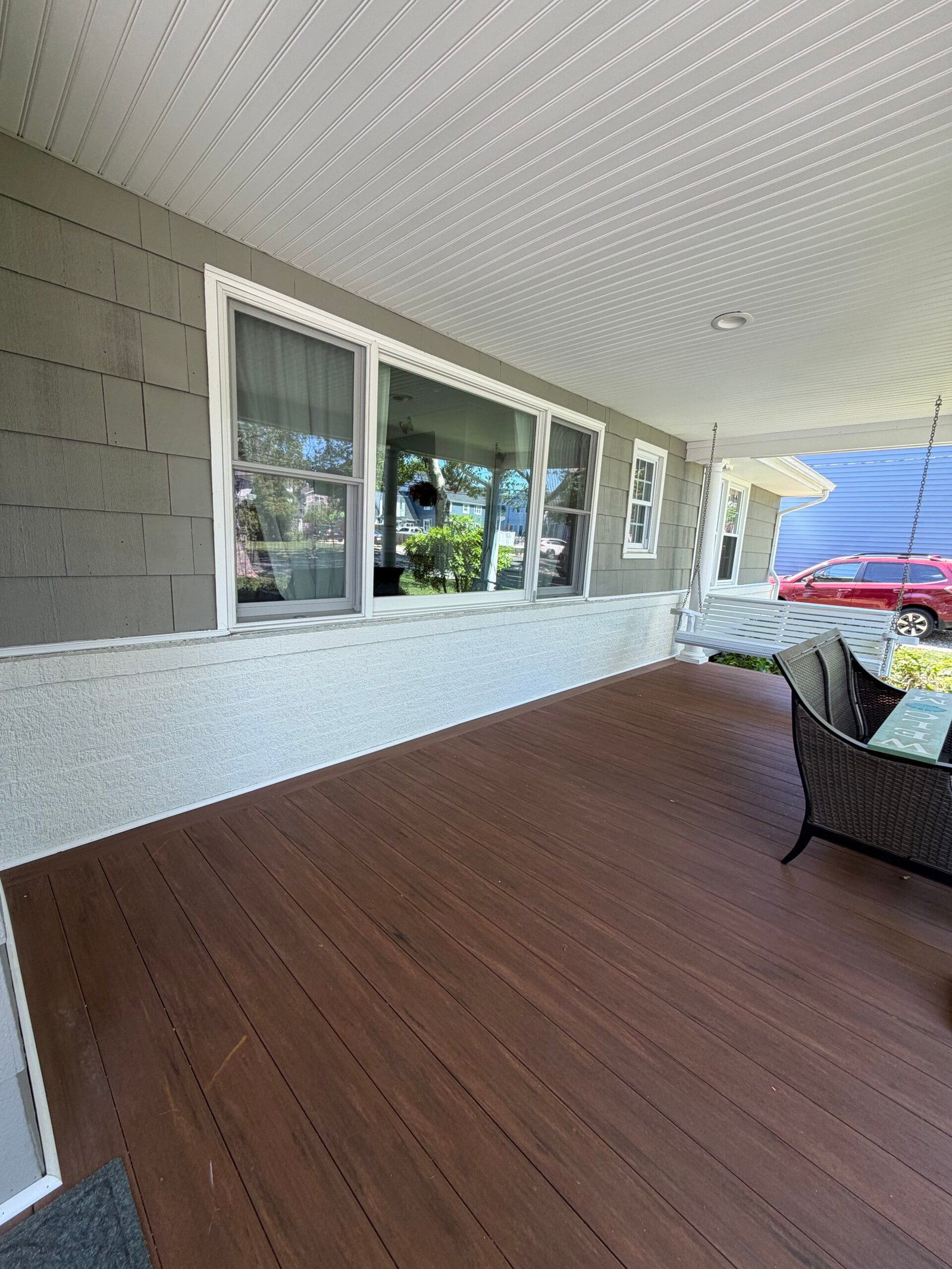 After: the covered porch with gray wall finishes, white accents and the floor uncovered.