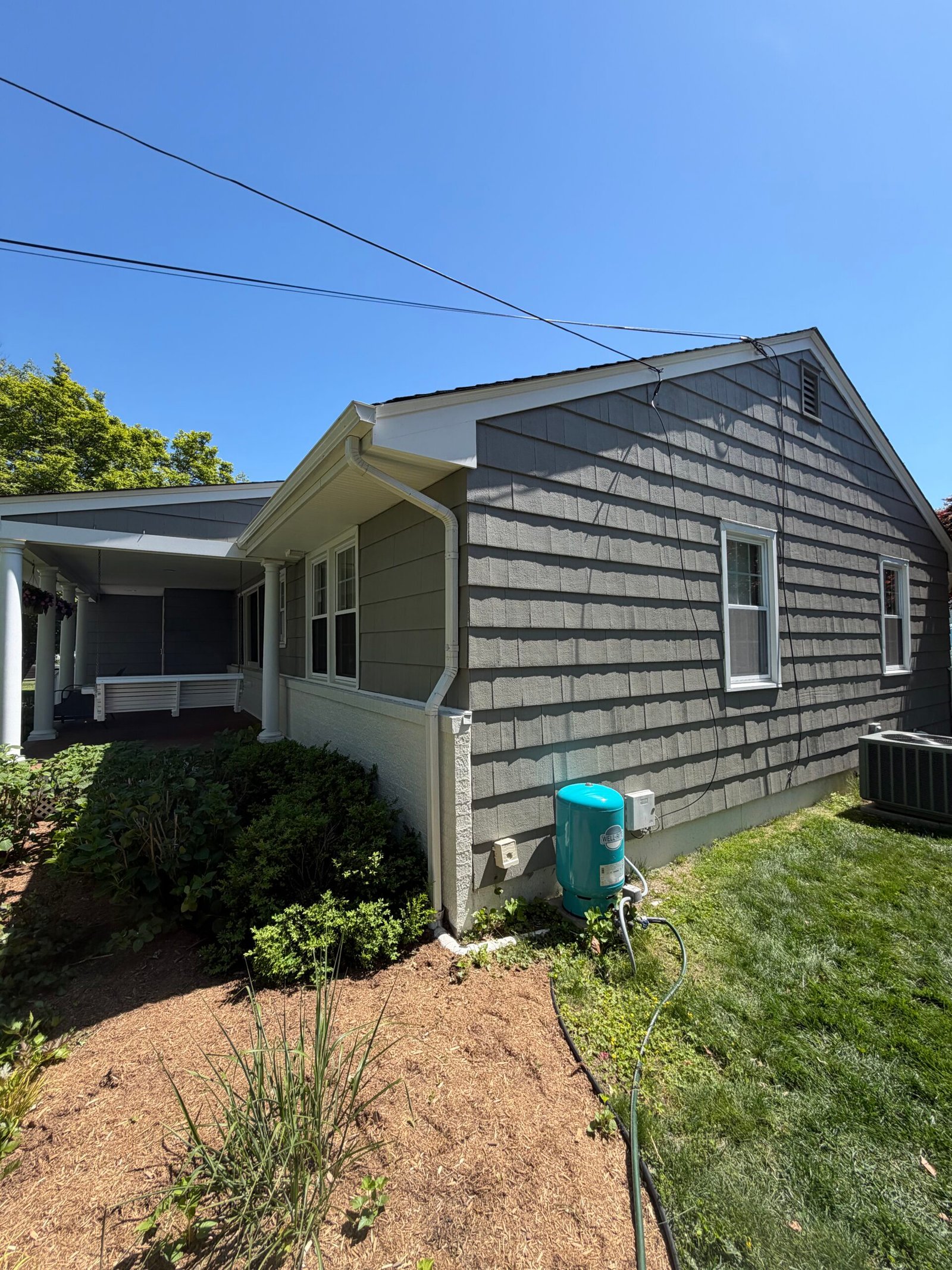 After: the side gable and its renewed gray exterior finish.