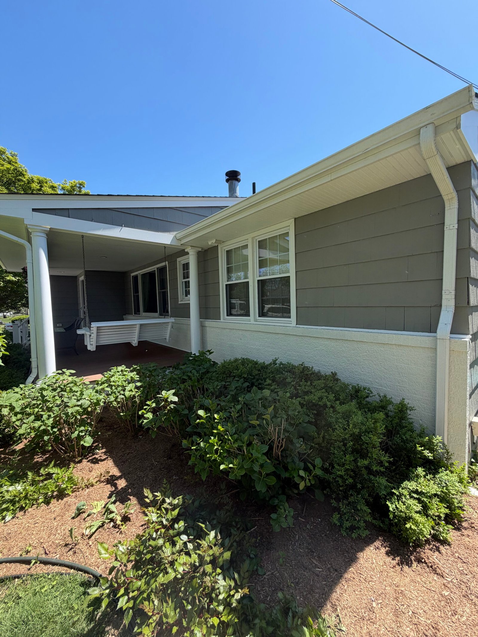 After: the side wall and windows beneath the white eaves.