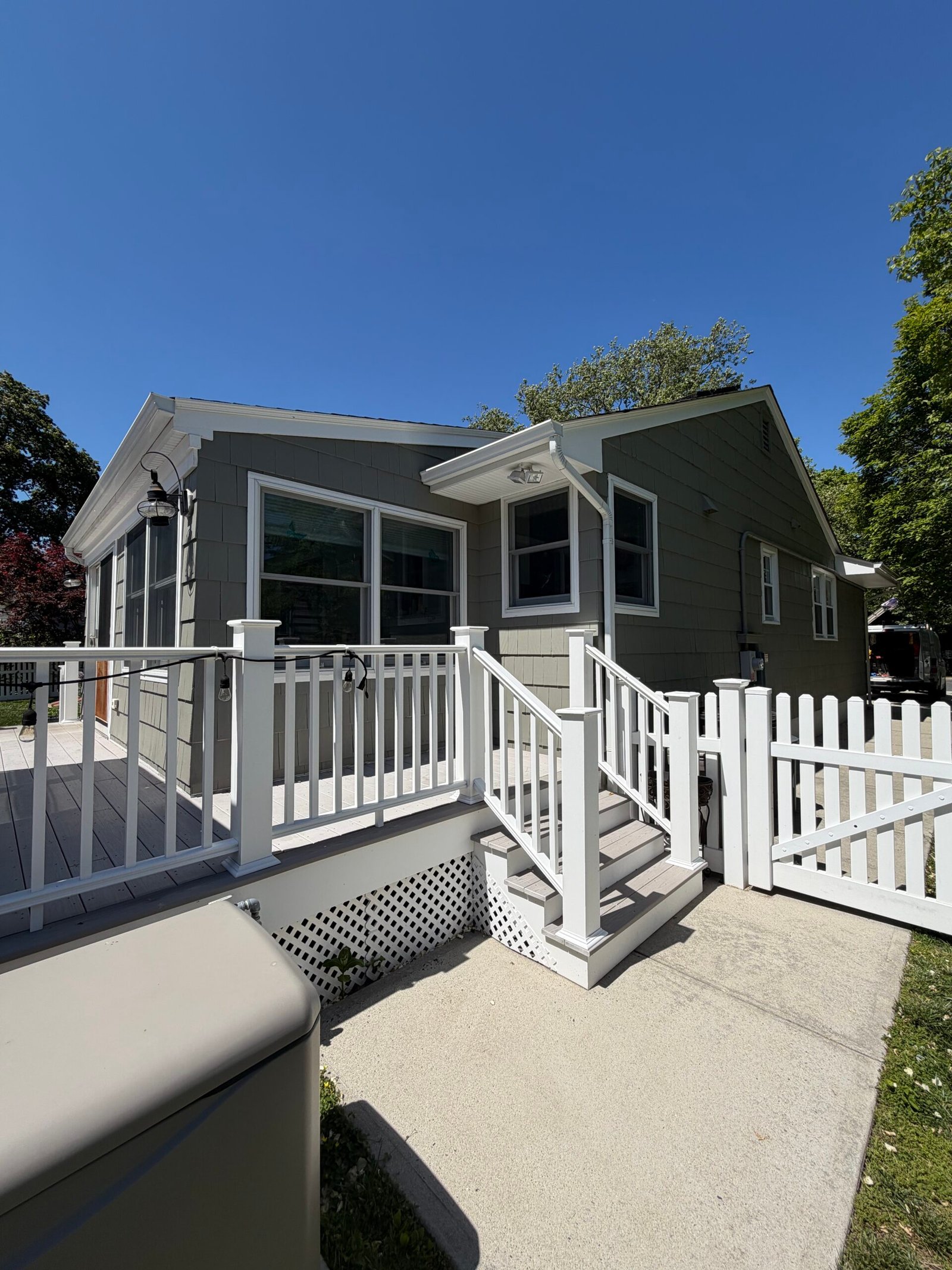 After: the completed exterior around the rear deck, steps and white railings.