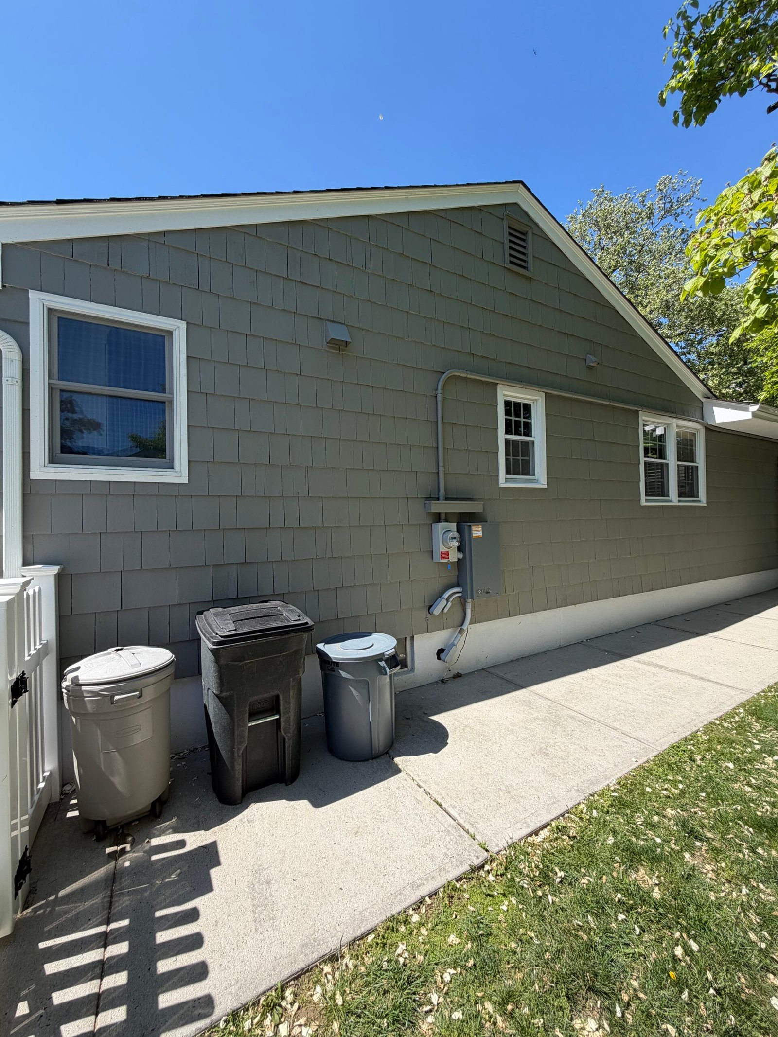 After: the finished side-rear elevation beside the paved service path.