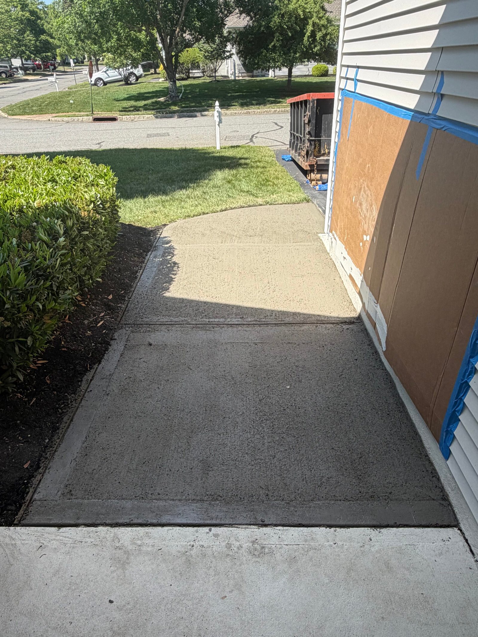 The newly placed walkway surface and joint line along the side of the house.