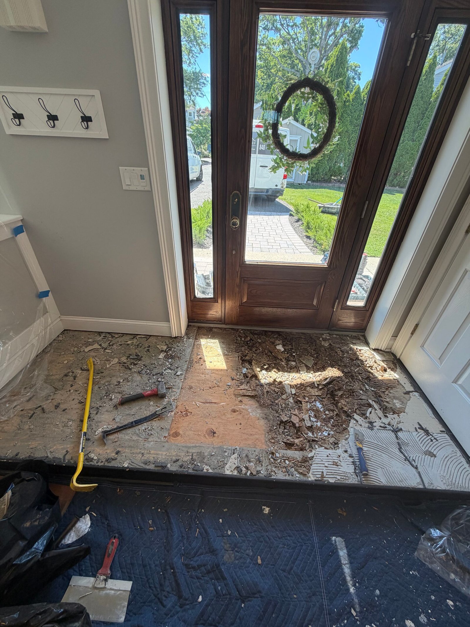 A wider removal view with the main entry opened and the adjoining floor protected.