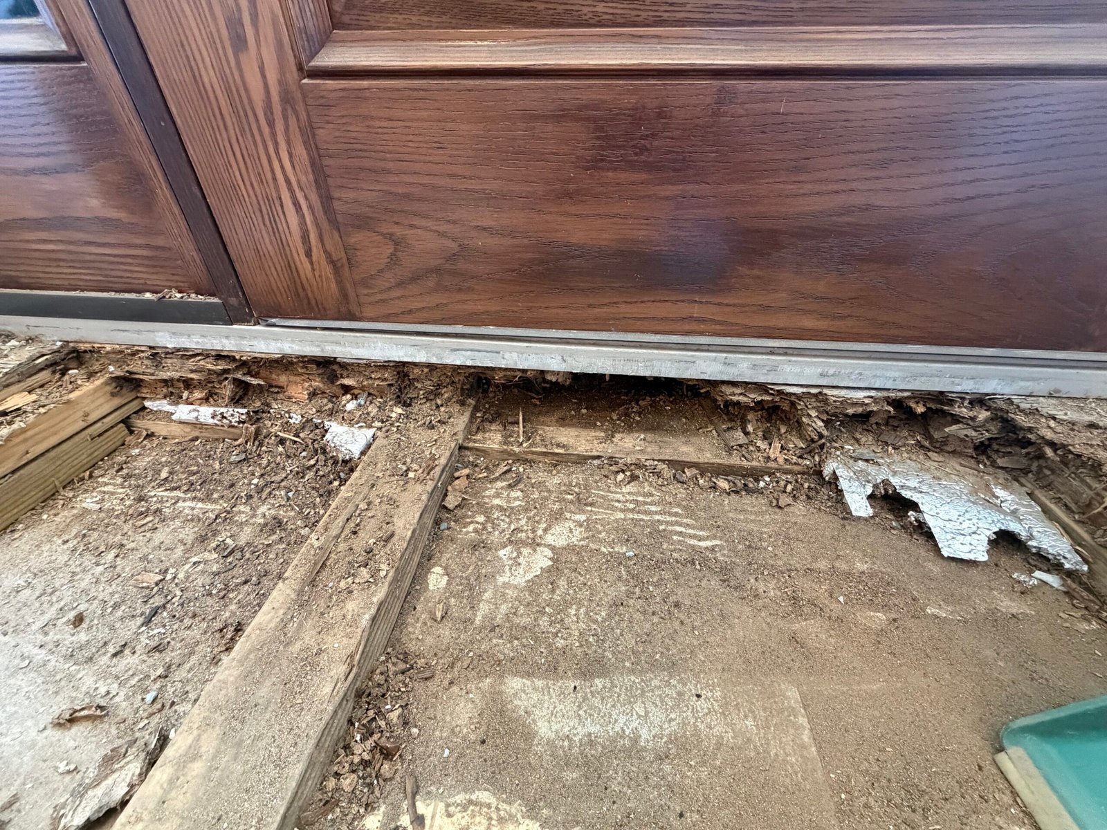 The opened floor at the lower edge of the door before the base was rebuilt.