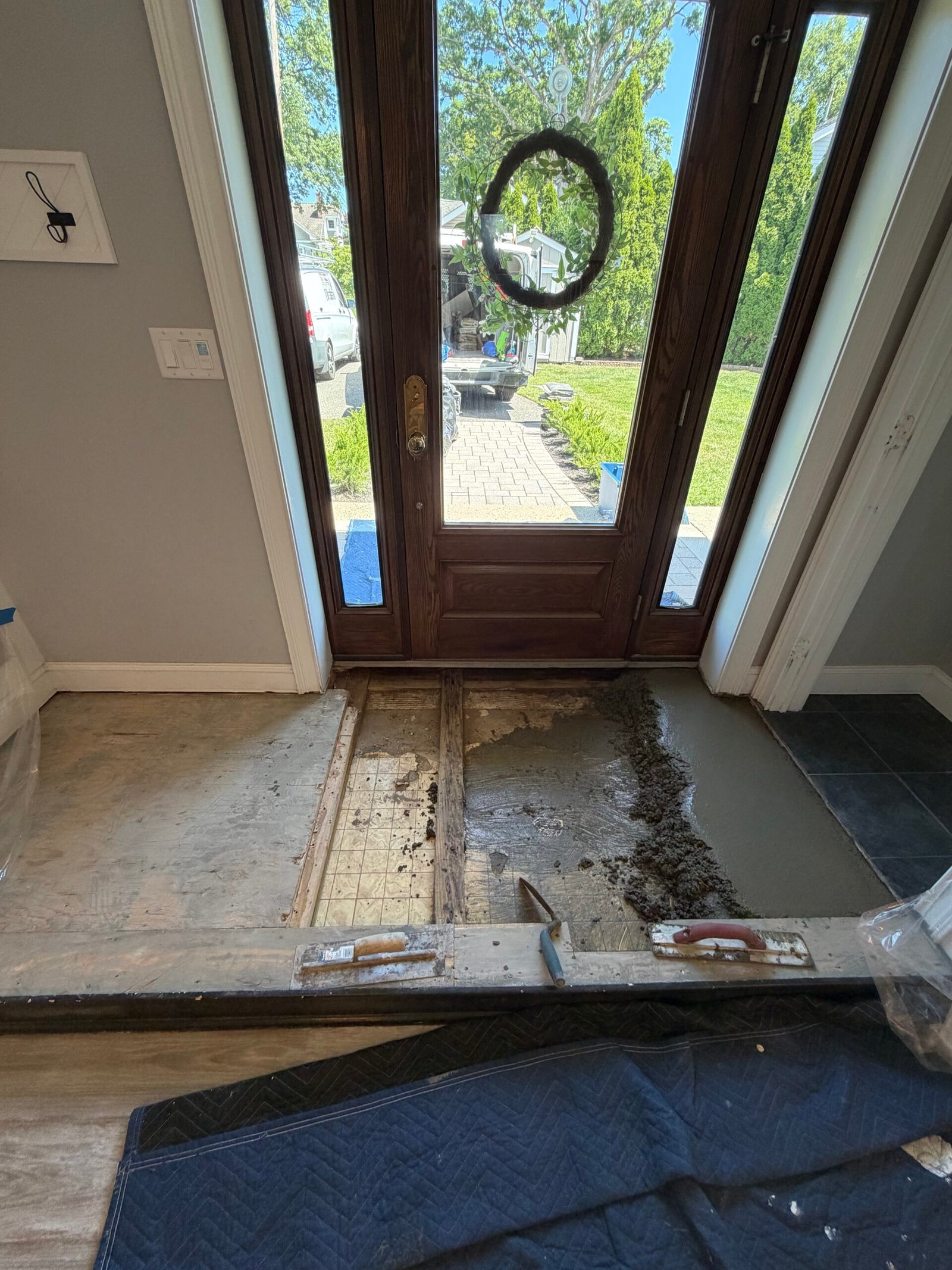 The base rebuild progressing across the entry beside the front-door threshold.