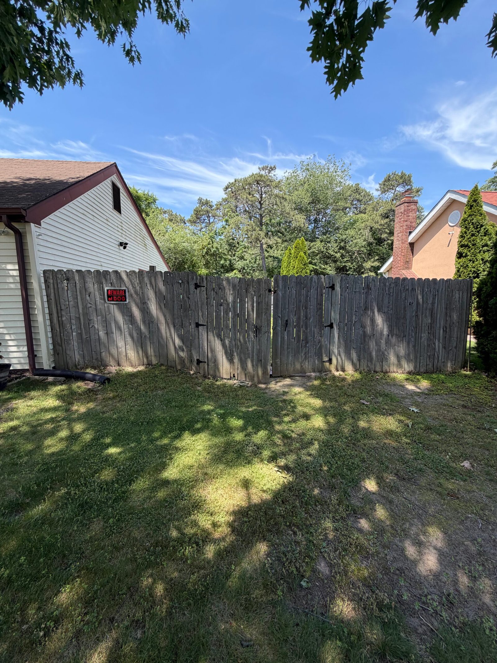 Before: the original weathered wooden fence closing off the yard.