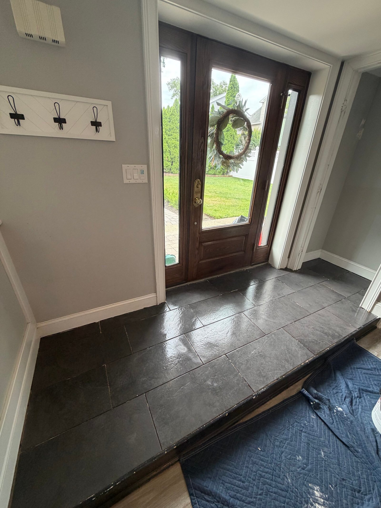 After: the finished dark tile and front edge viewed from the side of the entrance.
