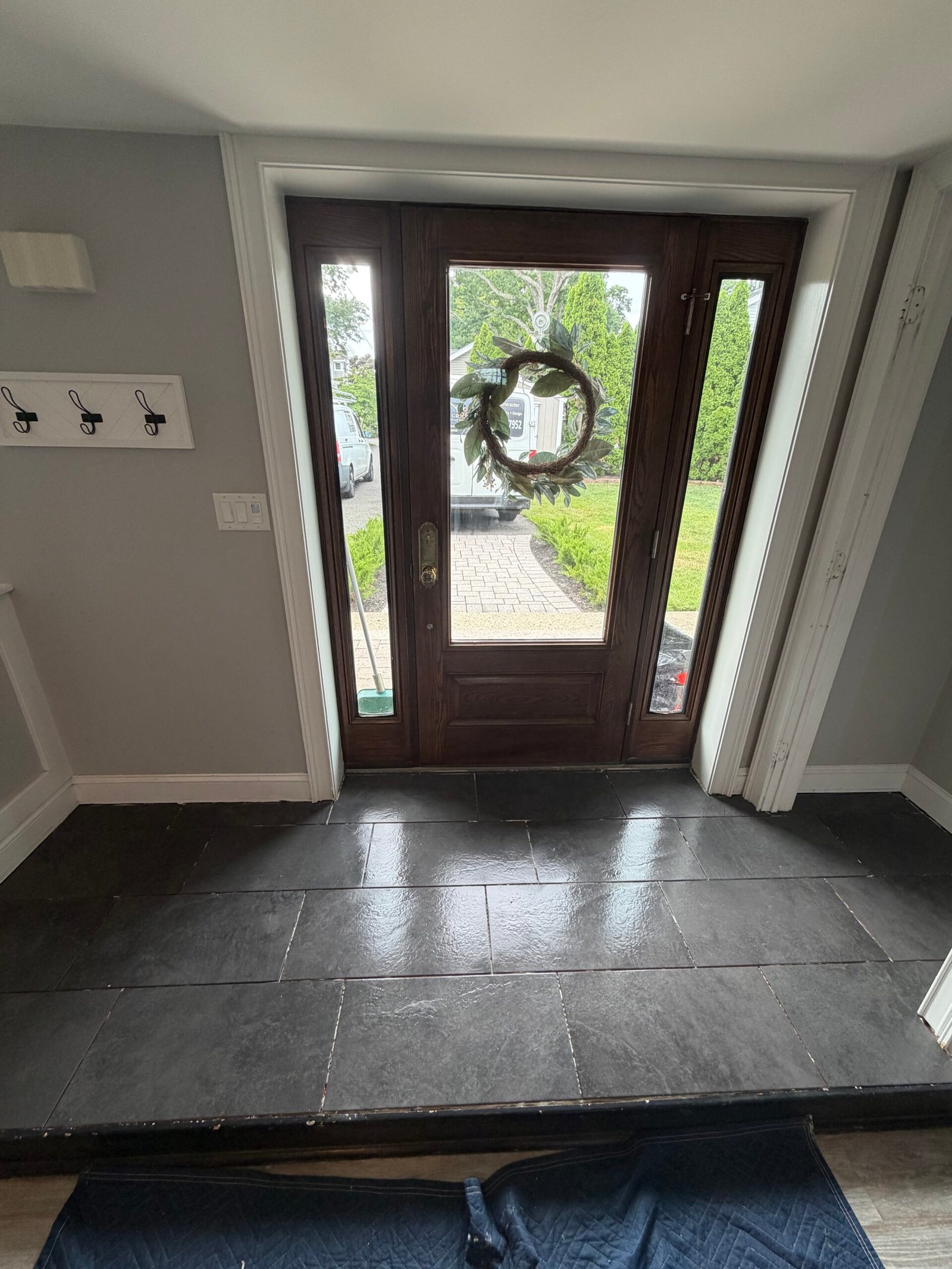 After: the completed tiled entry floor and its connection to the lower room floor.