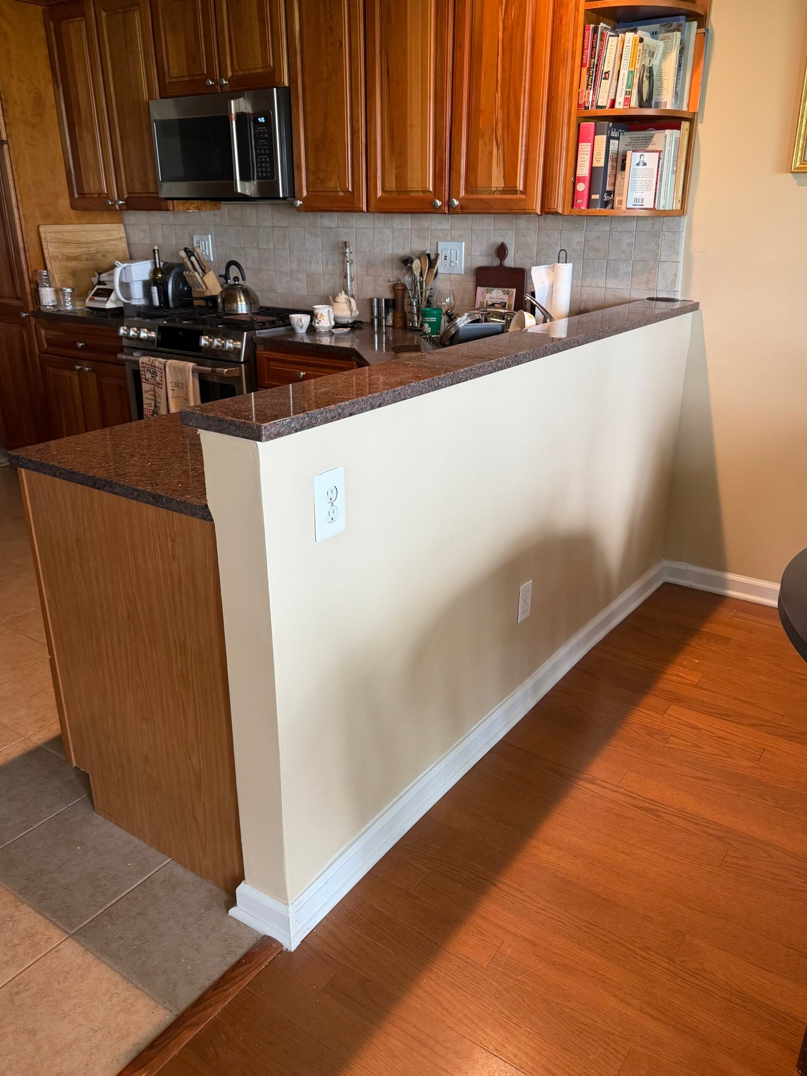The finished painted wall with white baseboard and outlet cover plates.