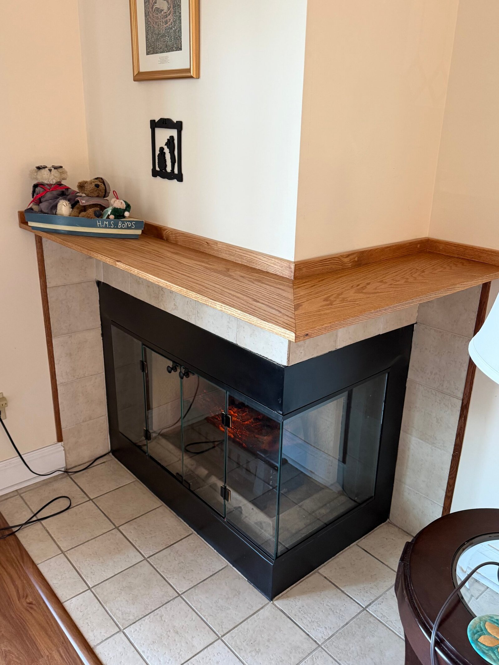 After: the finished corner fireplace and wraparound wood mantel viewed from the living room.