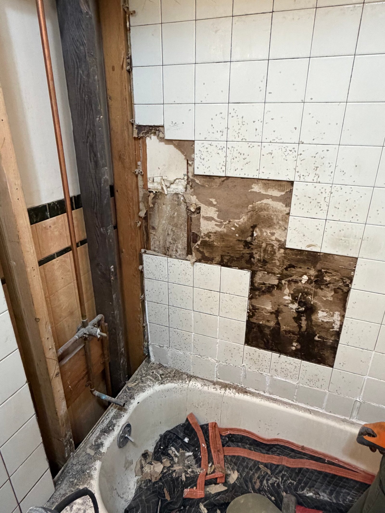 The back wall opened in sections as tile removal progressed.