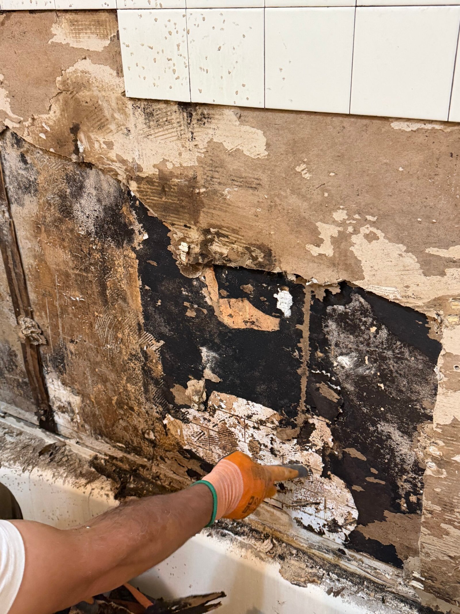 Removing loose material from the exposed back-wall surface.