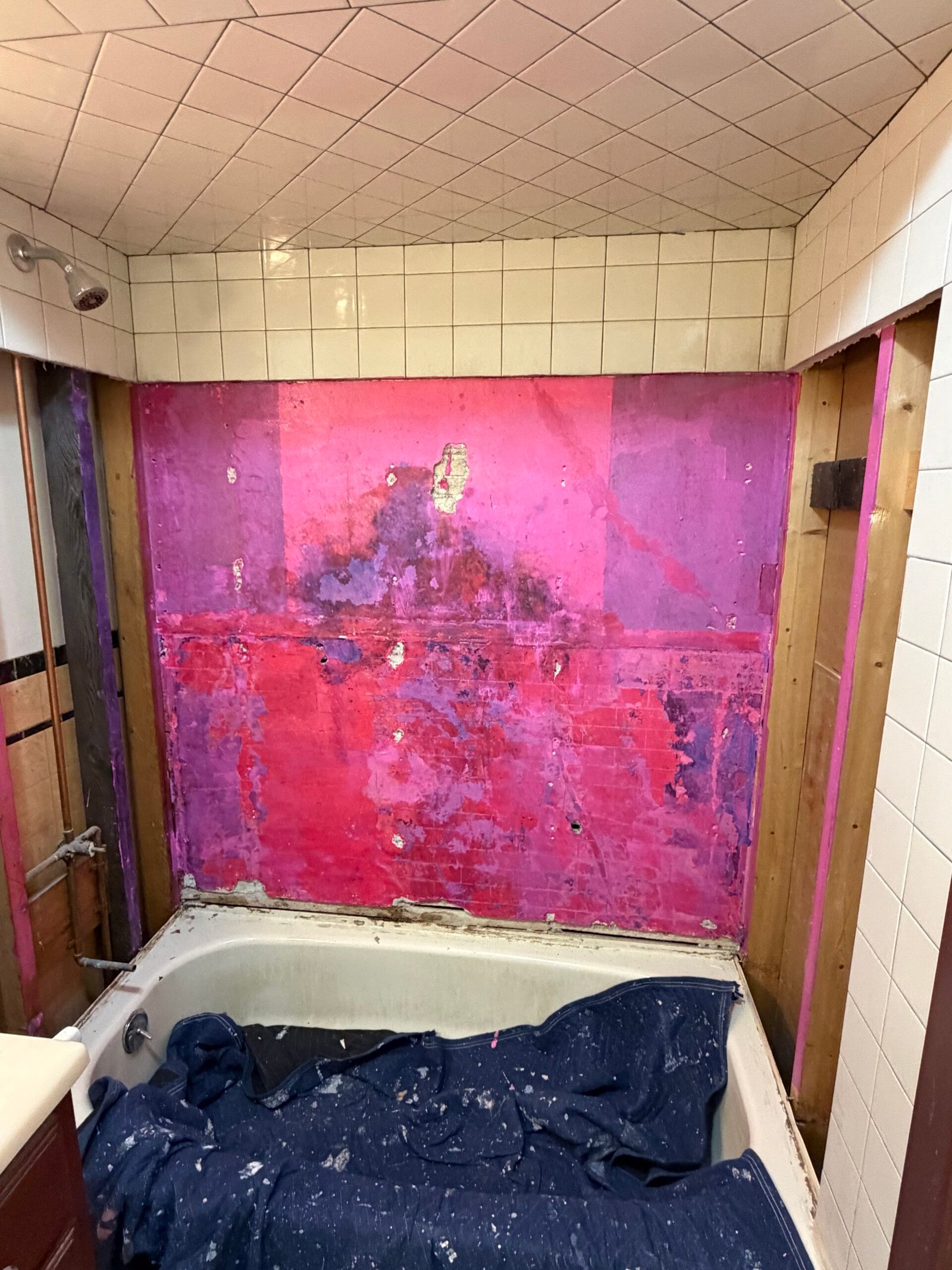 A colored coating visible on the prepared wall before the new surround.