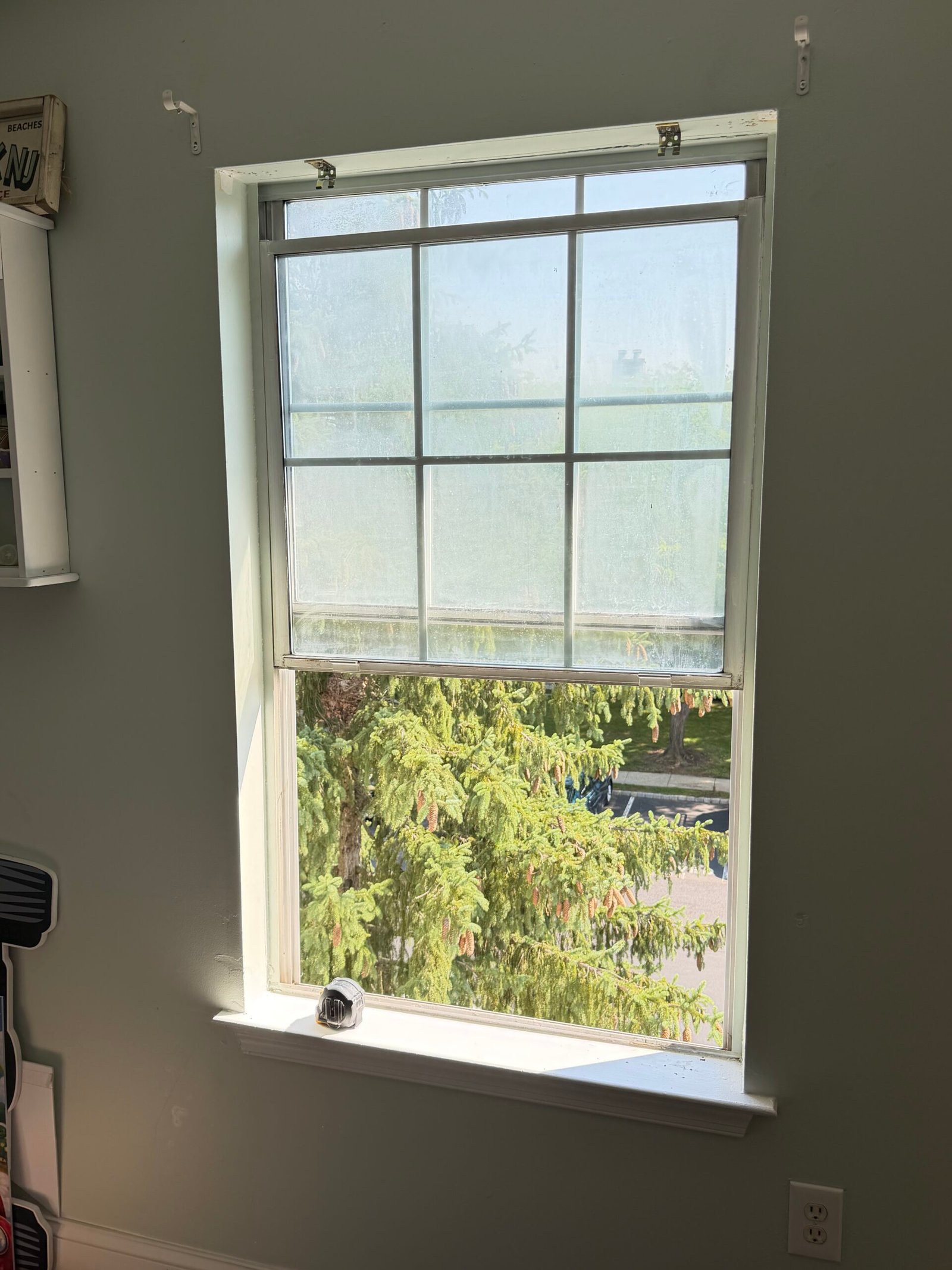 Before: the first bedroom window with its original trim and roller shade.