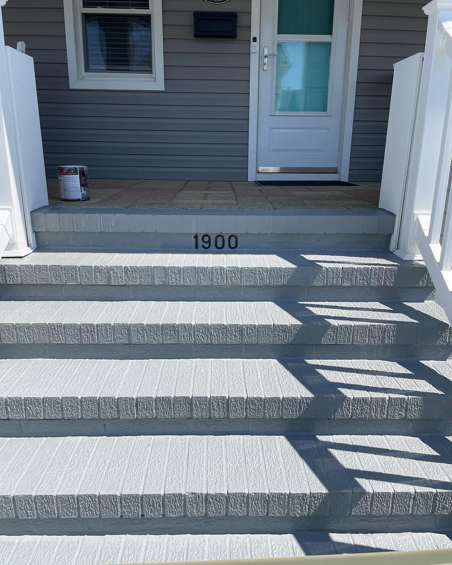 After restoration and painting: a textured gray finish across the entrance treads, risers and front edges.