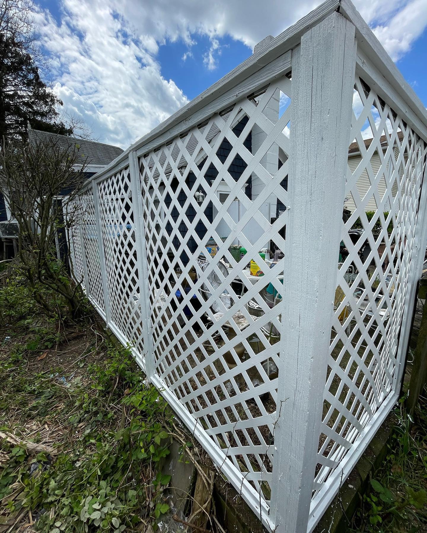 After renovation and painting: the lattice fence corner with a coordinated white frame and panels.