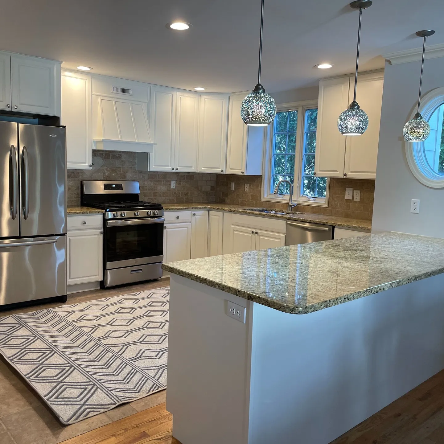 Completed view: the white-painted cabinetry seen across the kitchen and peninsula.