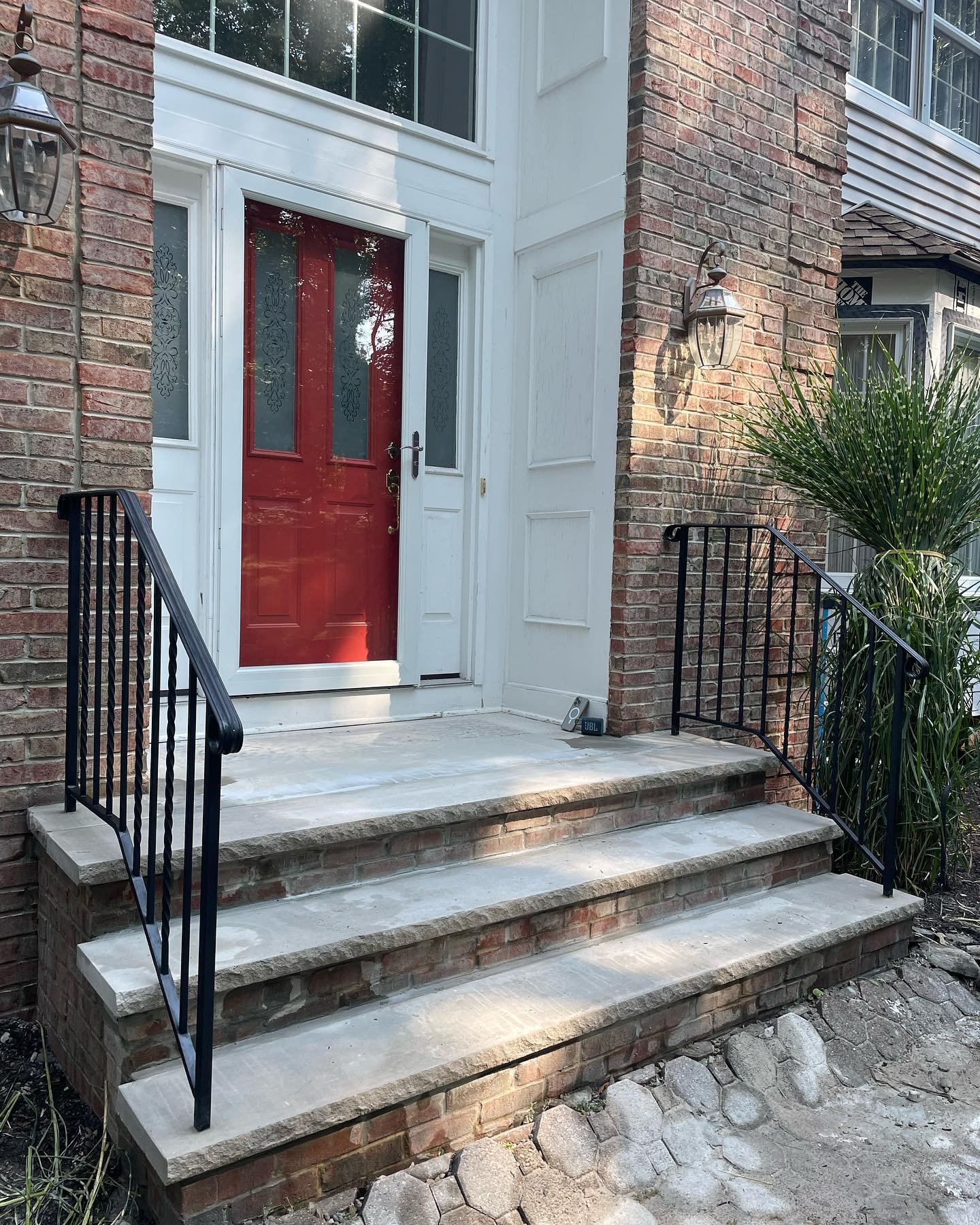The renewed limestone treads and landing with the black metal railings reinstalled, viewed from the side.