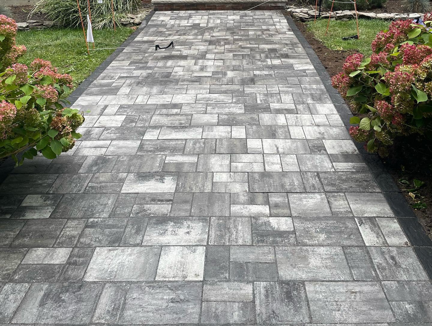 After: the new rectangular gray pavers and darker borders, viewed along the finished walkway.