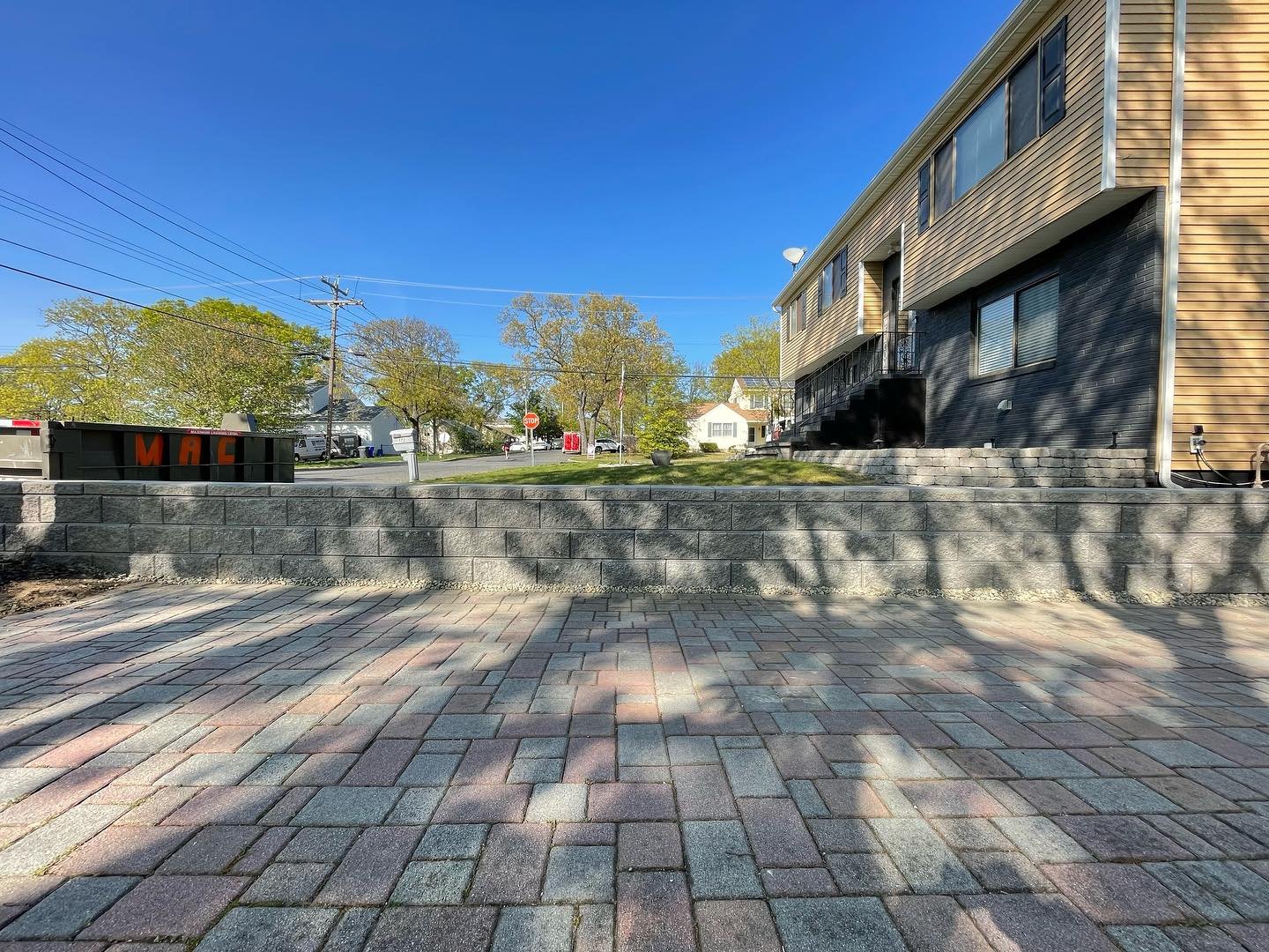 A low view of the finished block face and cap, showing the connection with the existing paved approach.