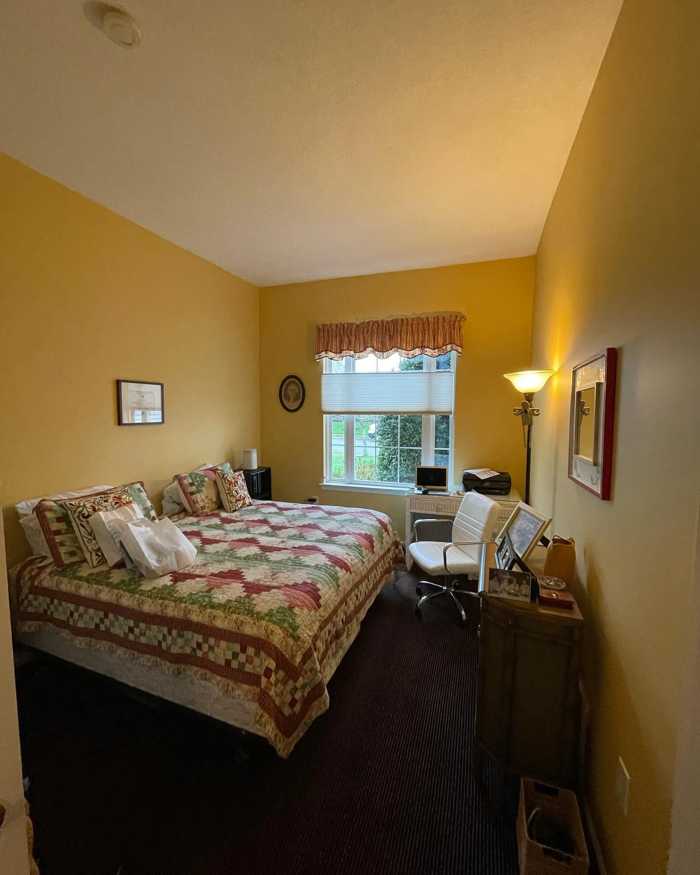 After: a warm yellow wall finish around the smaller bedroom window and bed.