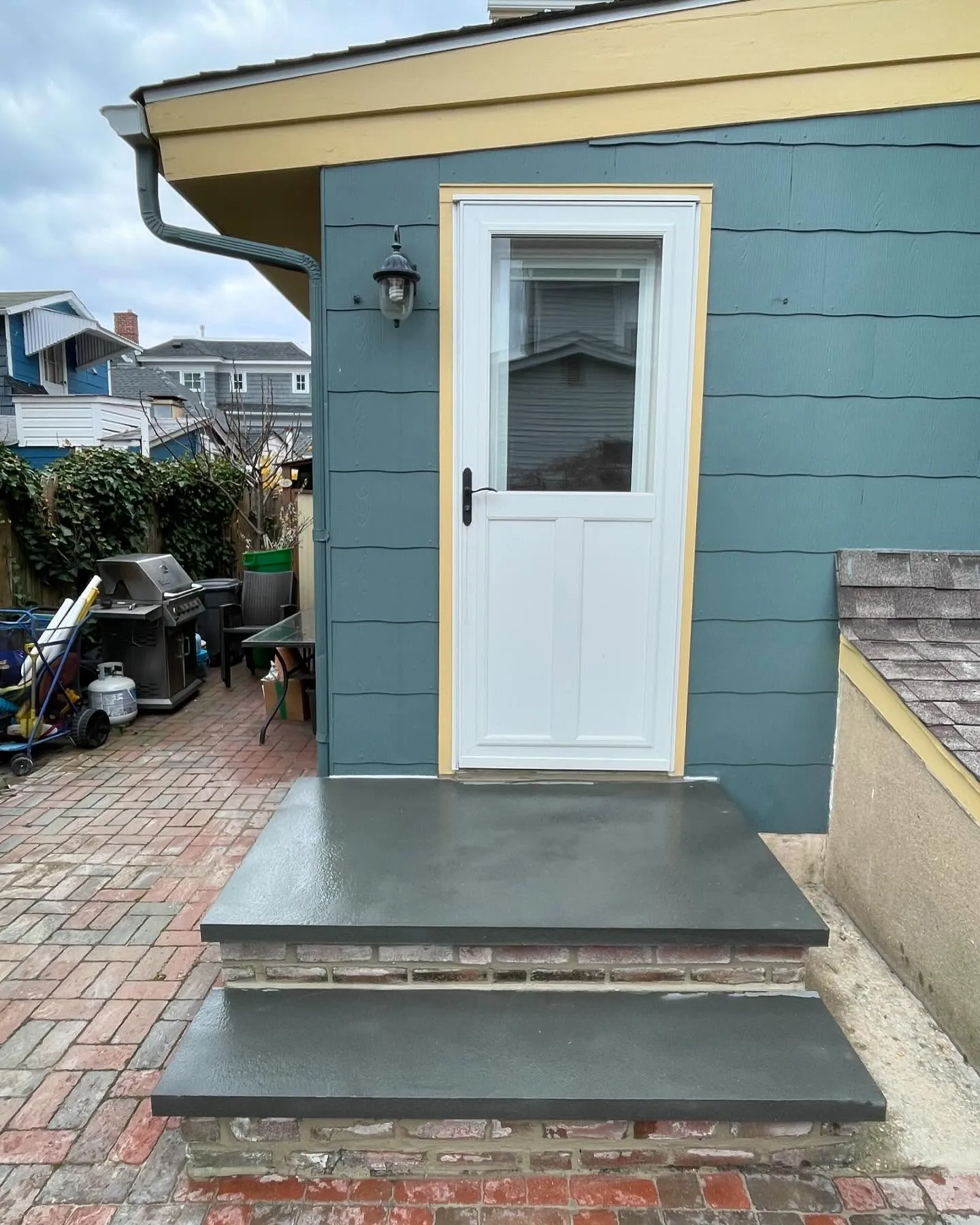 After: the entrance with a broad dark slab on the landing and a matching dark tread on the lower step.