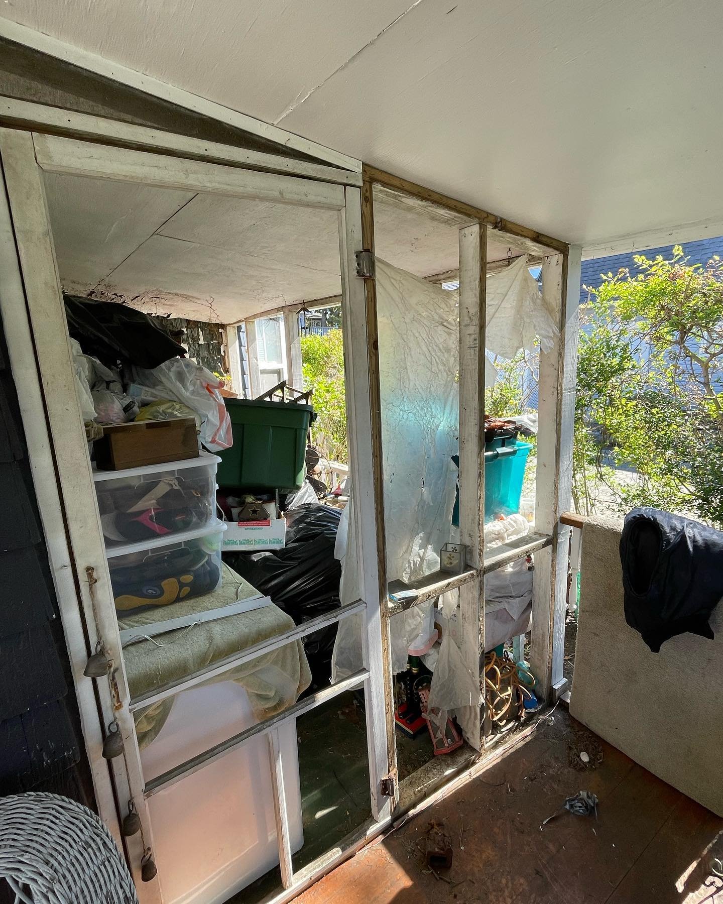 Before: torn and loose screening around the porch entrance, seen from inside.
