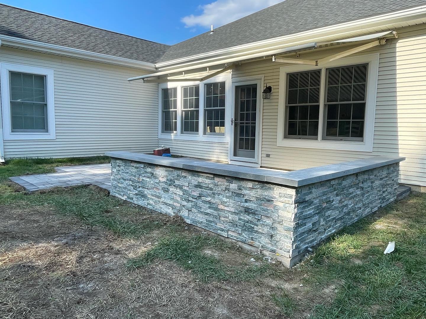 After: two low block walls finished with decorative stone facing and Bluestone caps.