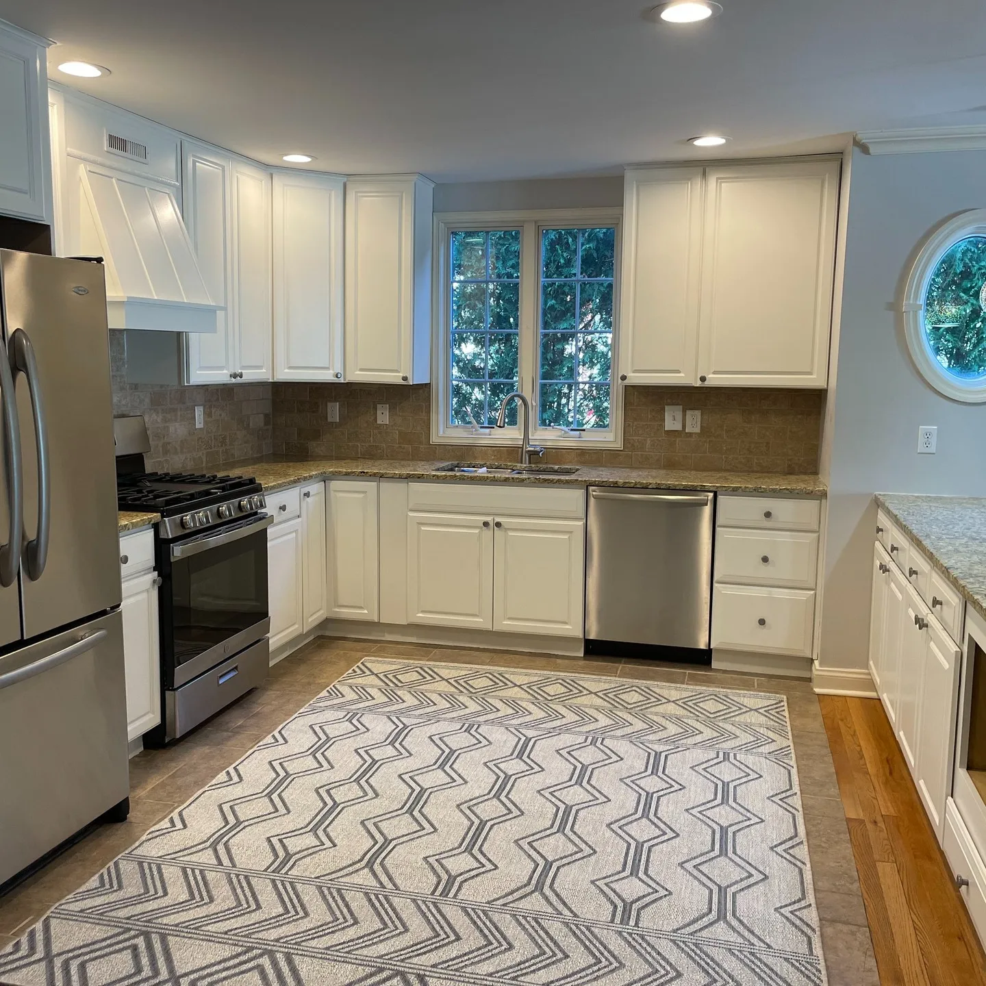 After painting: white upper and lower cabinet fronts around the cooking and sink areas.