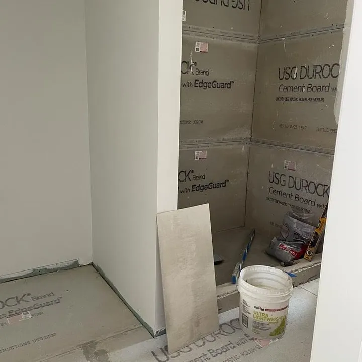Prepared cement-board surfaces at the shower and adjoining sink area before tile installation.