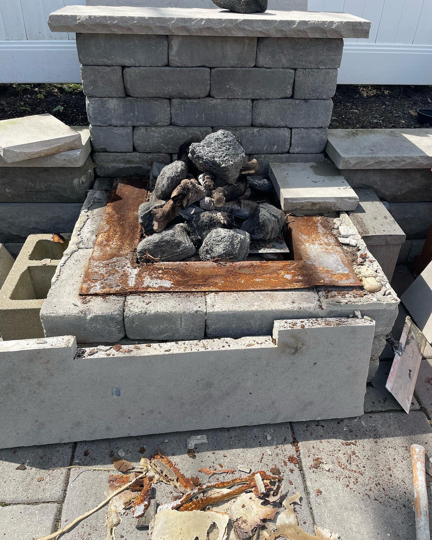 Starting work stage: the top finish partly removed, exposing the old metal surround around the fire opening.