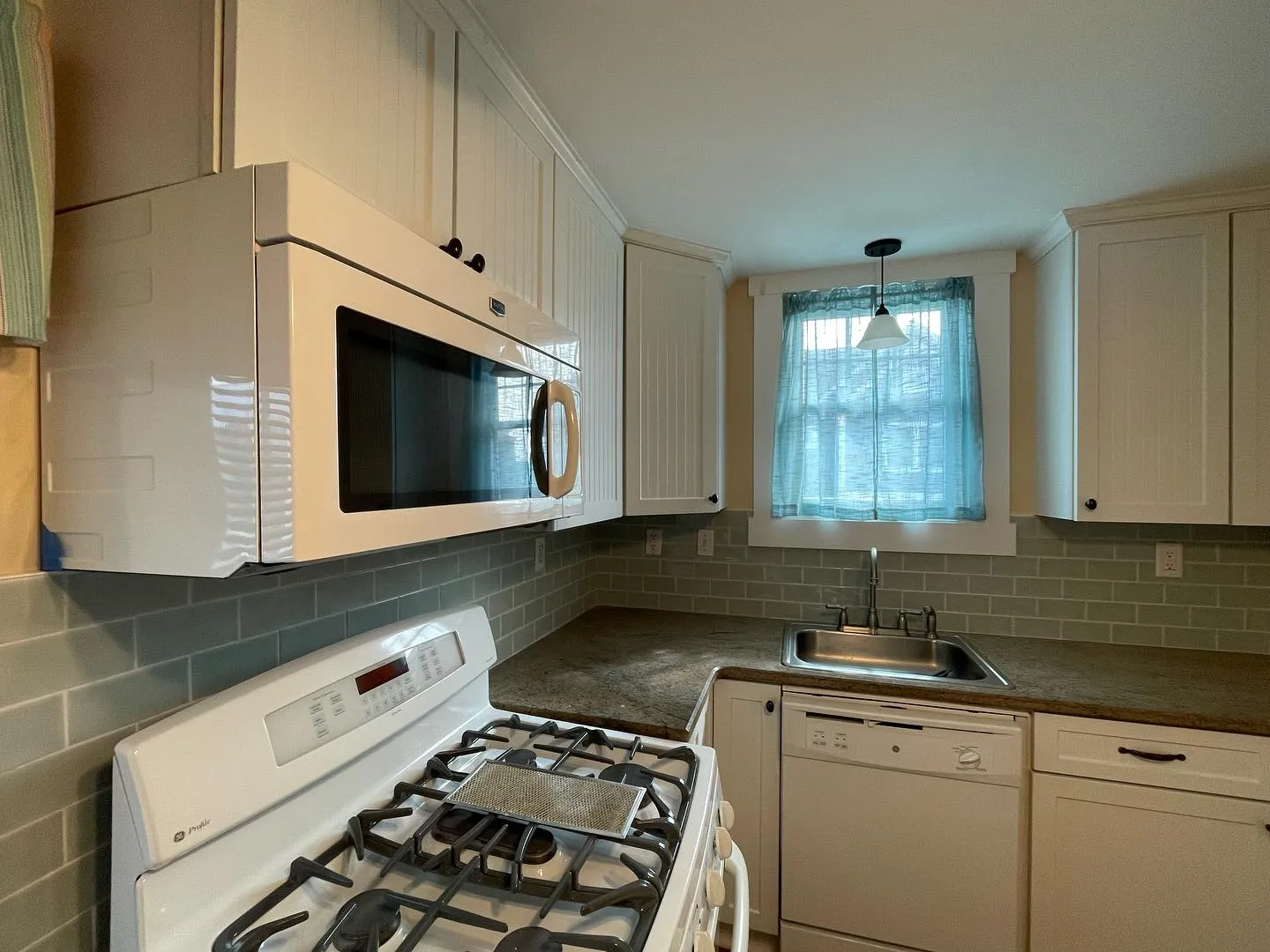 After: the installed tile backsplash behind the range and along the sink wall.