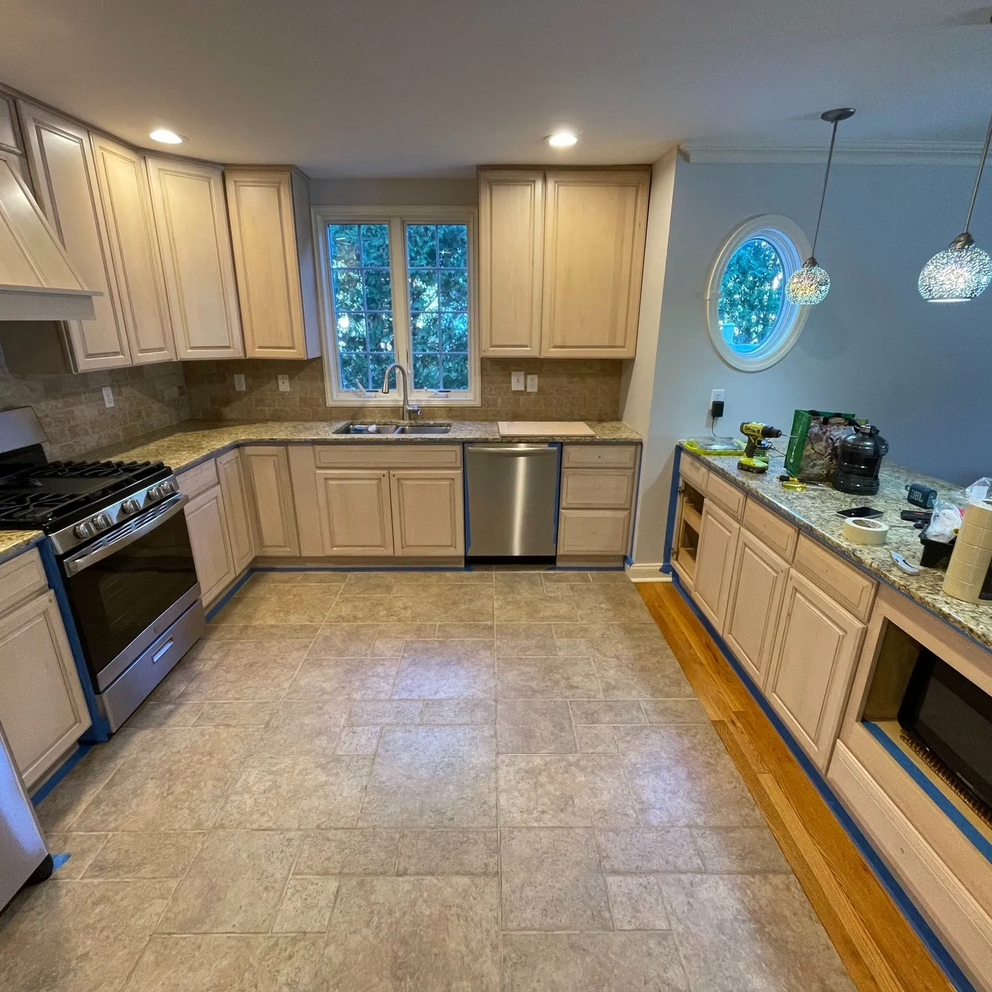 Earlier view along the sink and peninsula, with the original cabinet finish and masking in place.