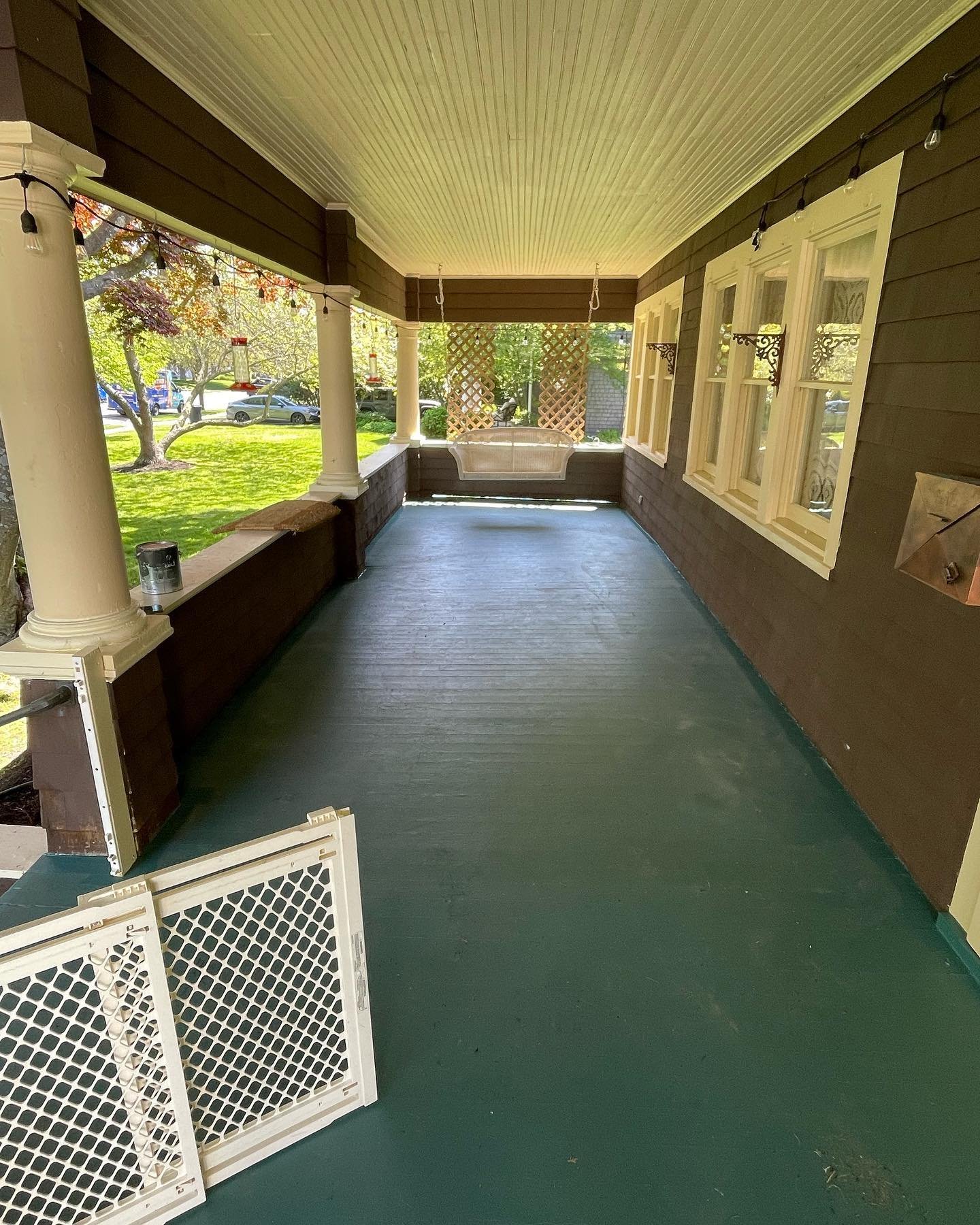 Before: the long covered porch floor, with dull and worn areas in the earlier painted finish.